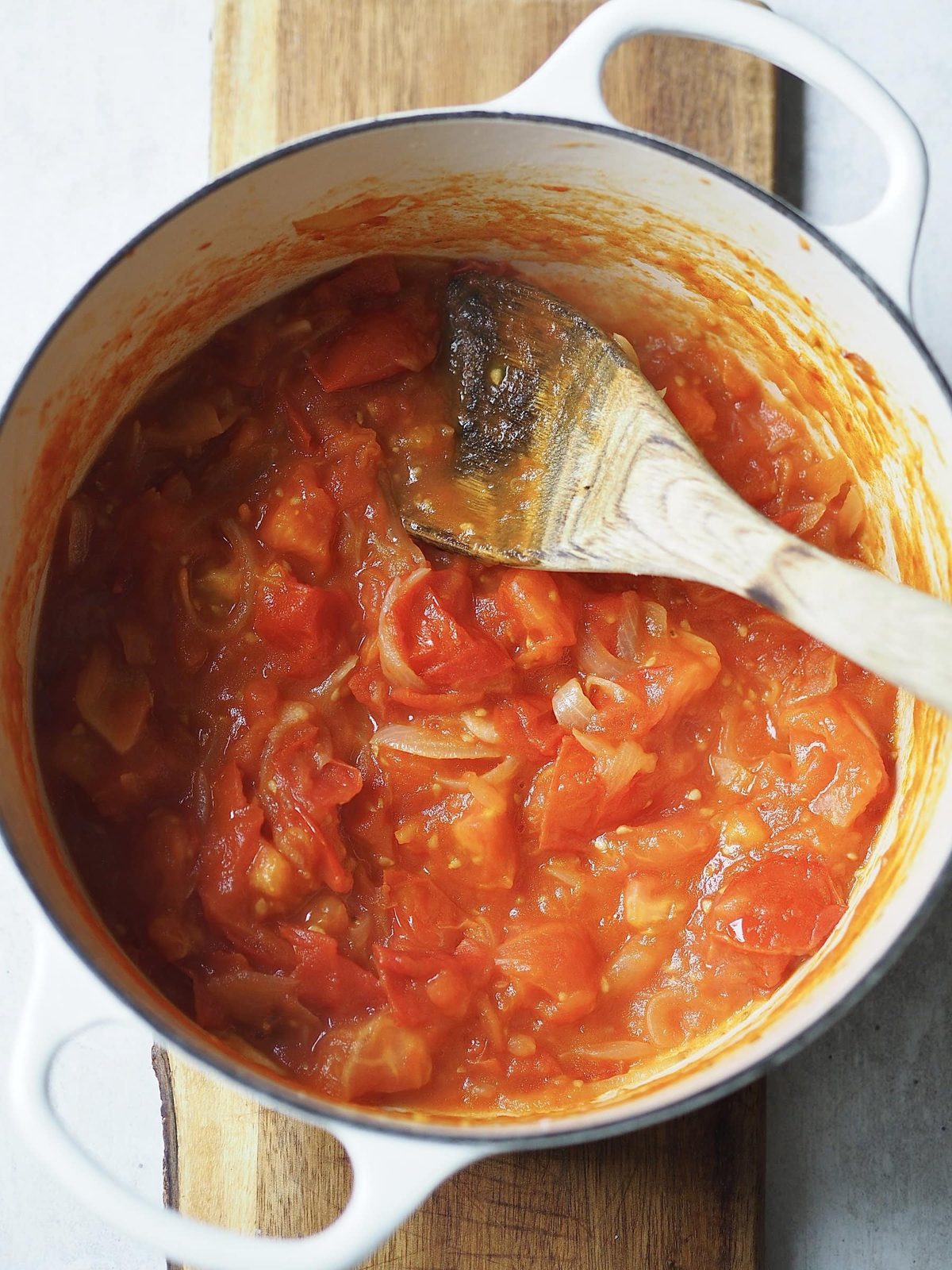Adding tomatoes and garlic and simmering.