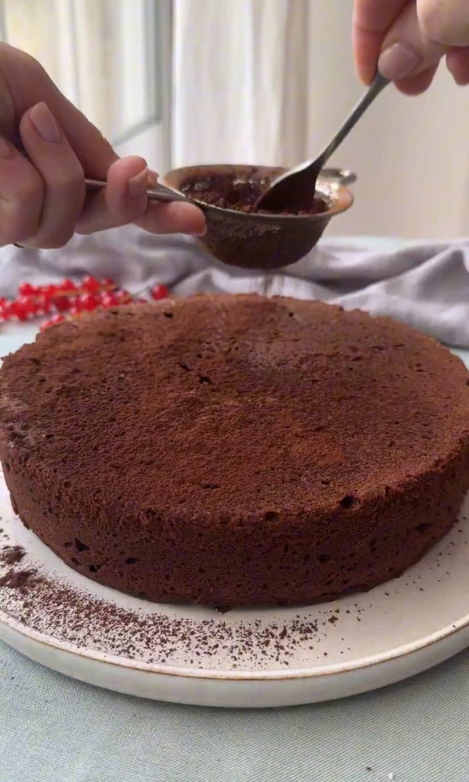 dusting torta caprese with cocoa powder.