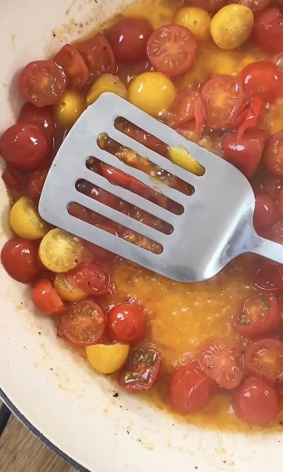 pressing the tomatoes with the spatula.