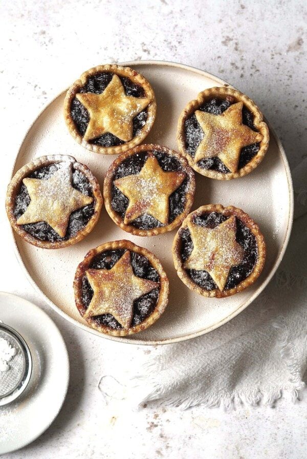 Plate of mince pies dusted with icing sugar.
