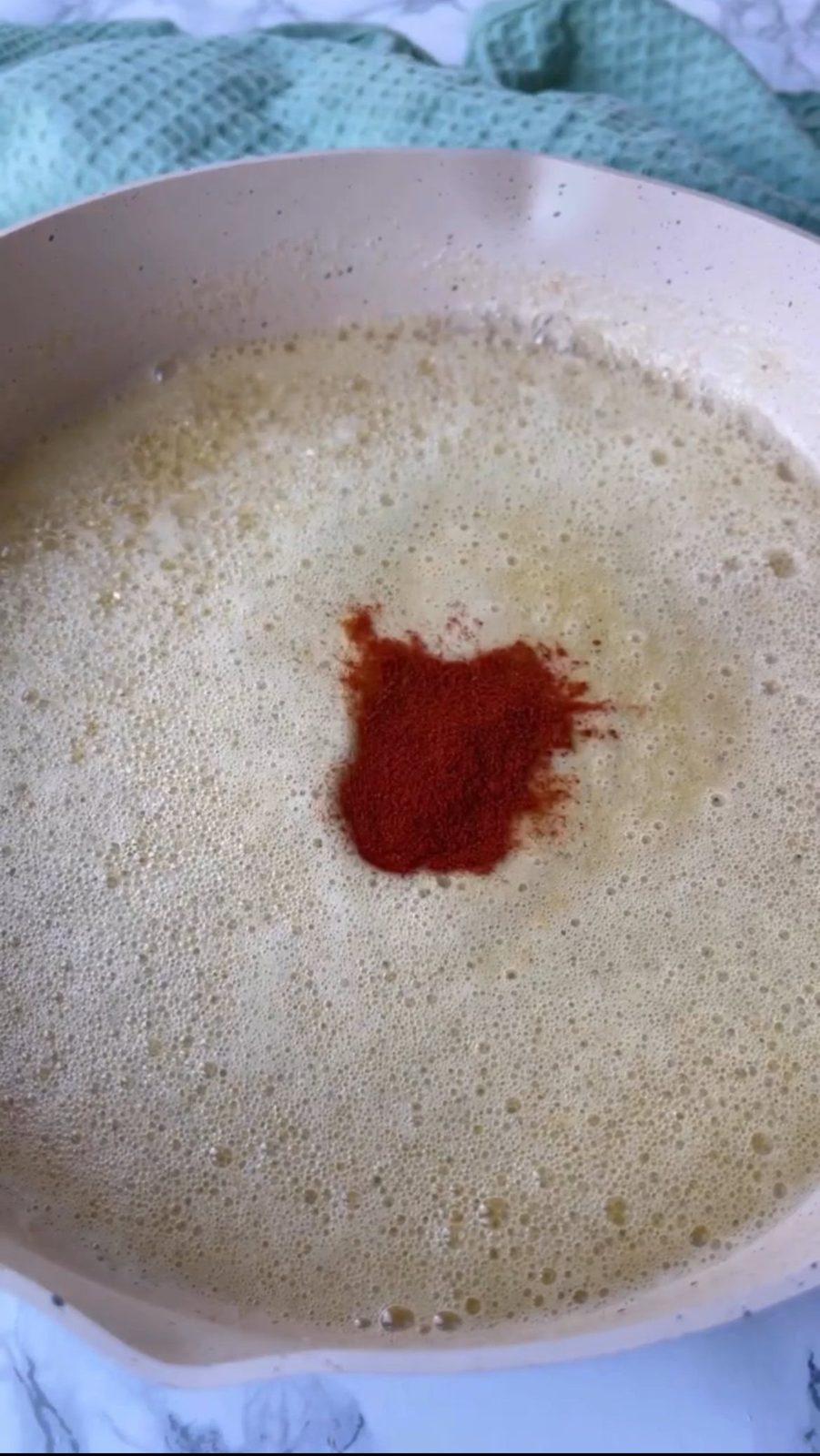 Melting butter and seasoning it with paprika.