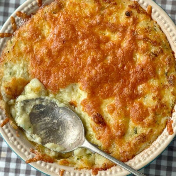 twice baked mashed potatoes in a dish with cheese on top.