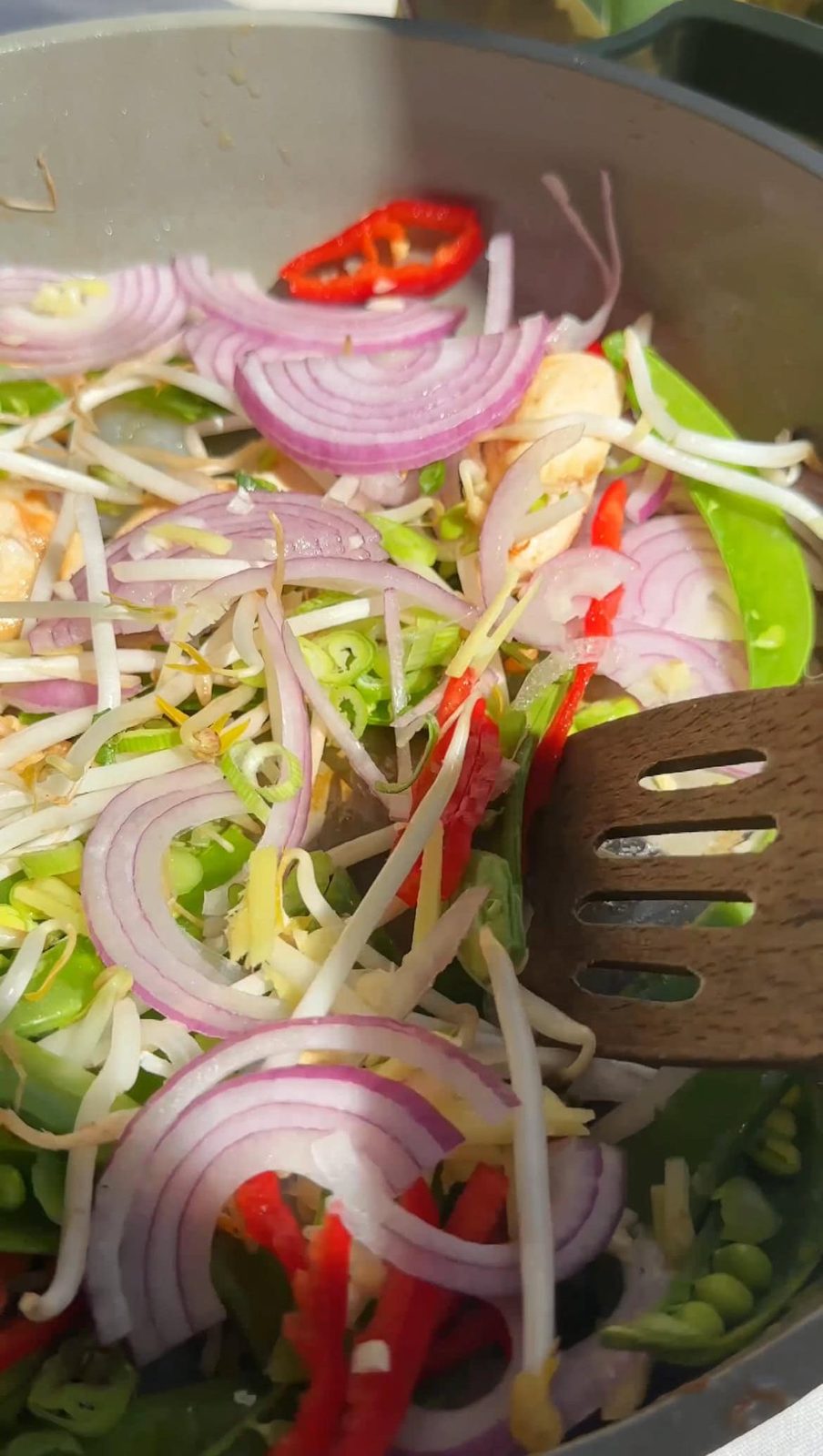 Stir-frying vegetables for Pad Thai.