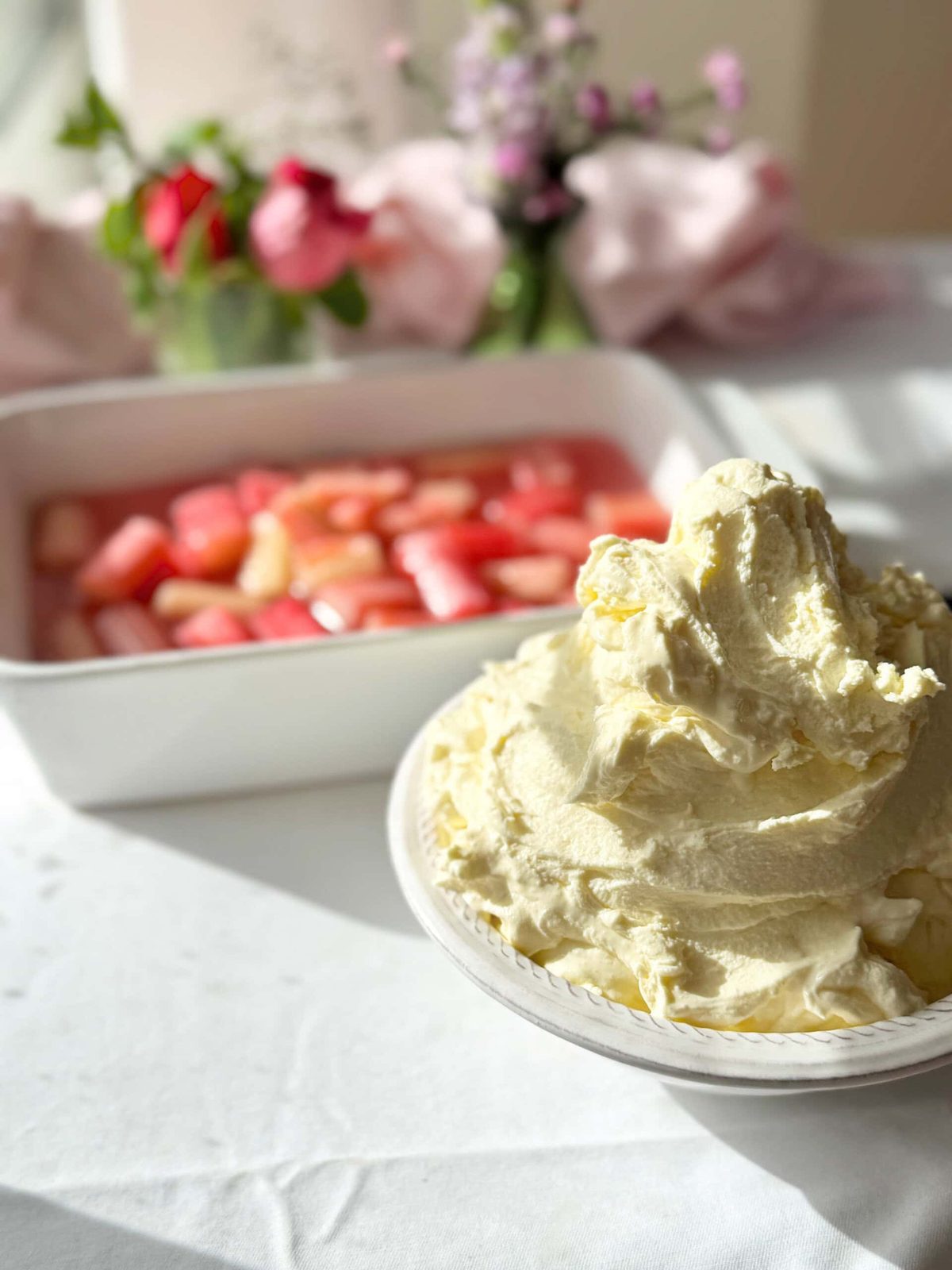 Whipped mascarpone cream in bowl with poached rhubarb.