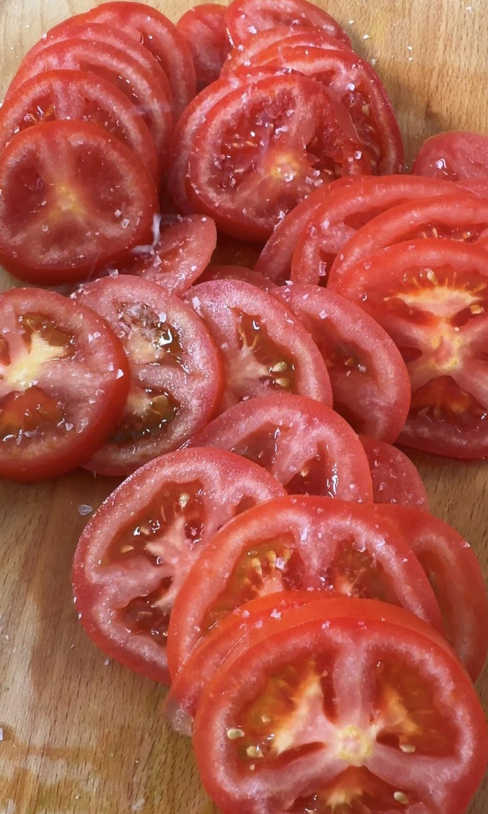 seasoning tomatoes with salt.