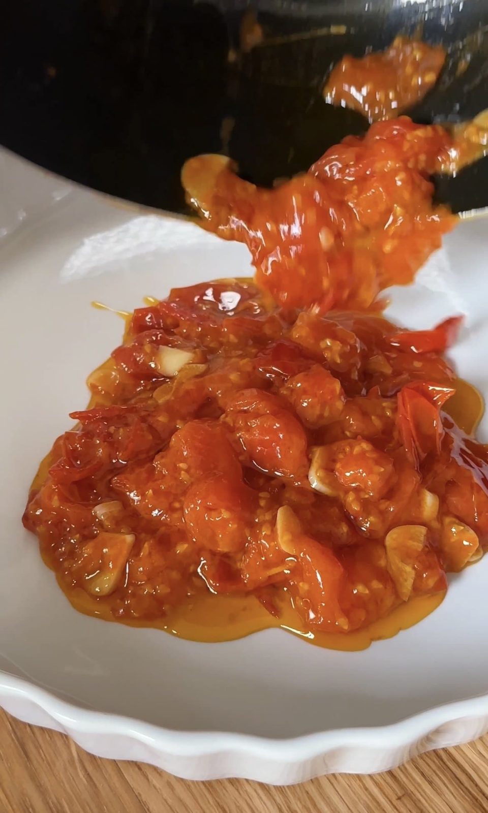 adding tomato sauce to the bottom of the dish.