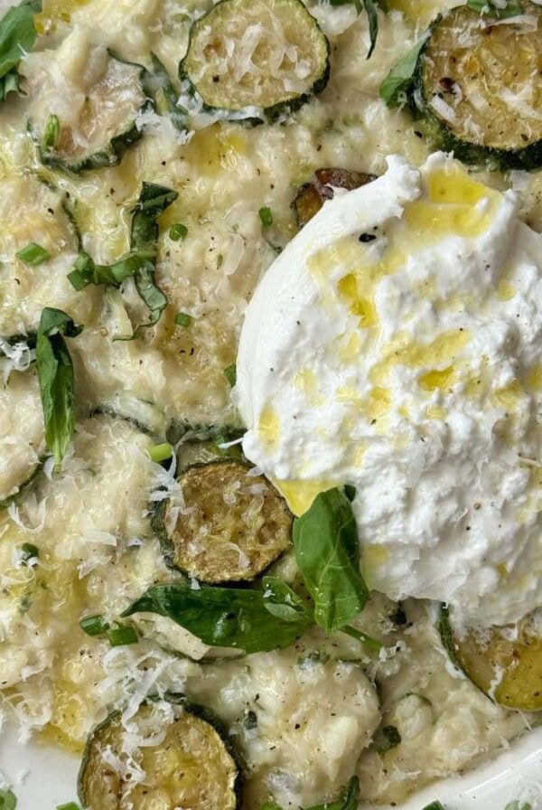 creamy zucchini risotto in a bowl with mozzarella on top.