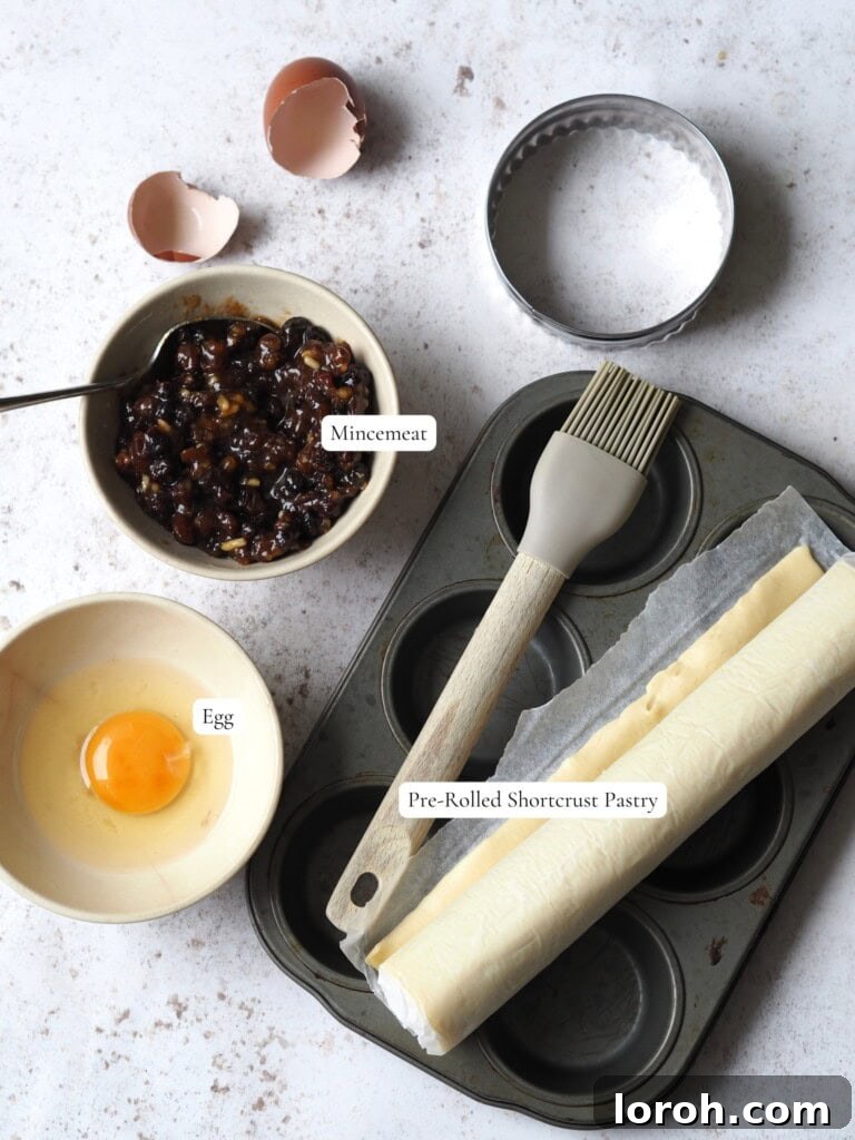 Labelled mince pie ingredients laid out on a table: shortcrust pastry, mincemeat, egg, and icing sugar.