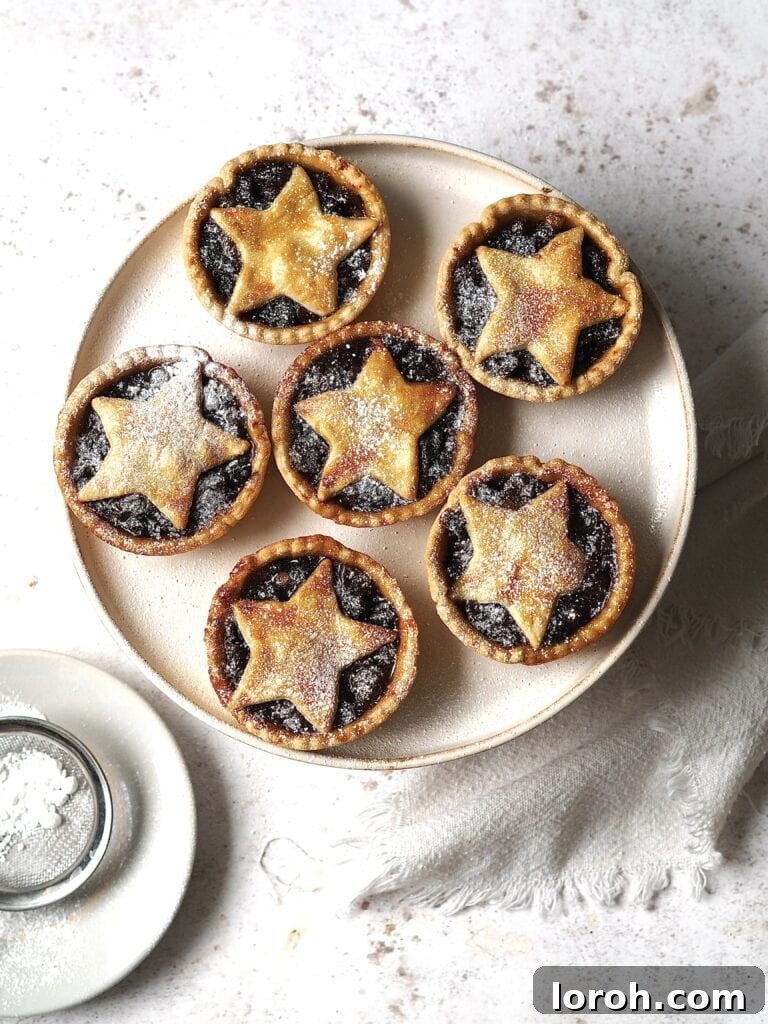Plate of mince pies dusted with icing sugar, ready to serve.