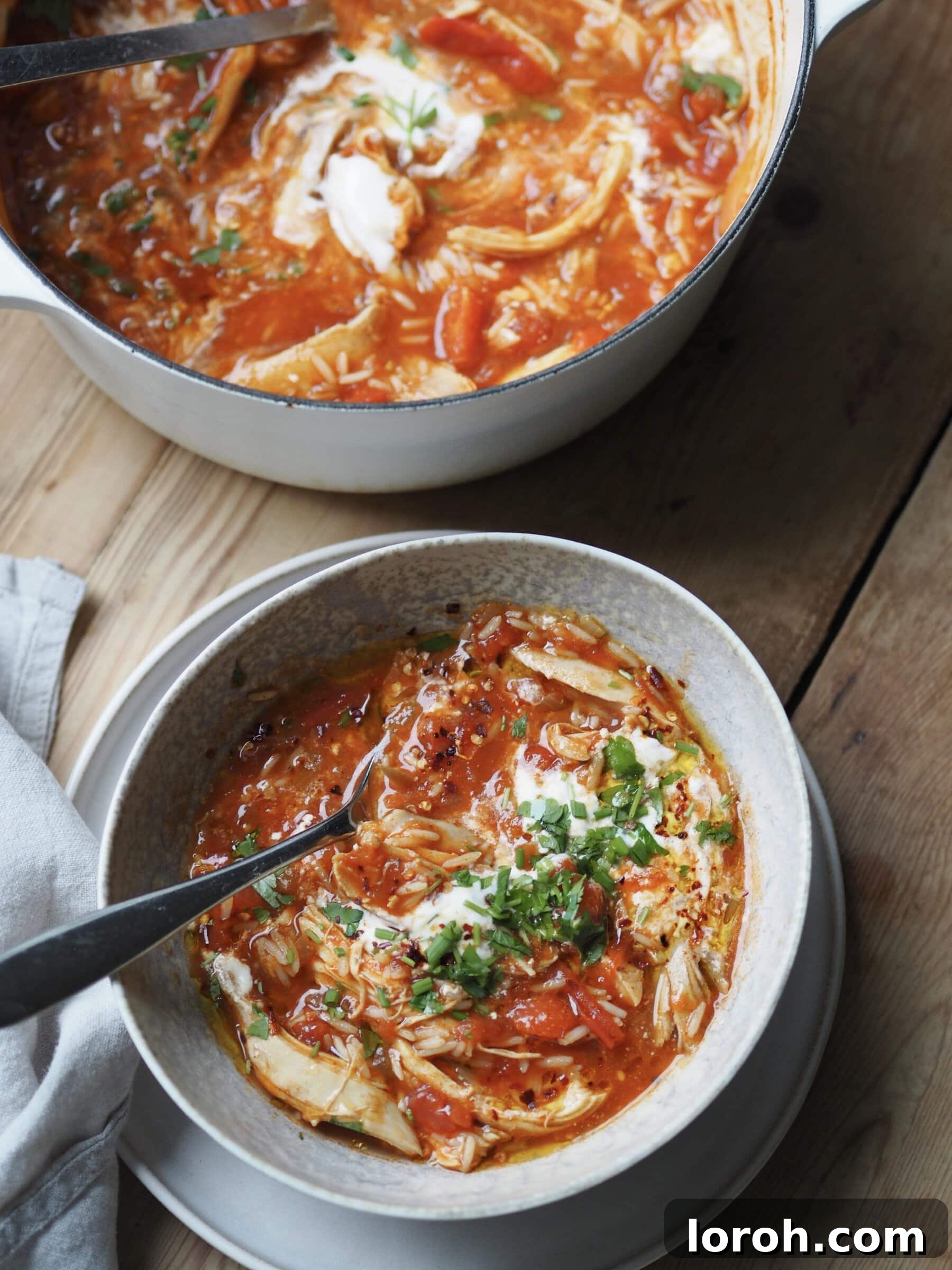 Serving Heartwarming Turkey and Rice Soup in a rustic bowl, garnished with fresh herbs and a swirl of cream.