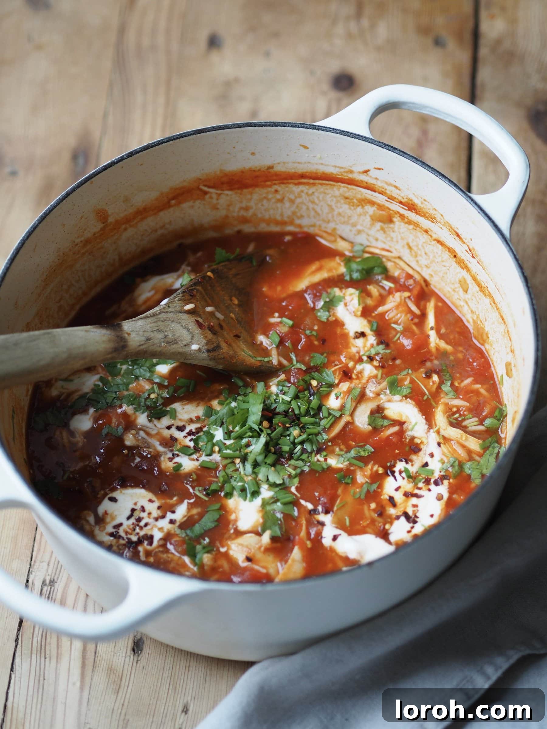 Turkey and Rice Soup simmering in a large pot with a wooden spoon, ready to be served.
