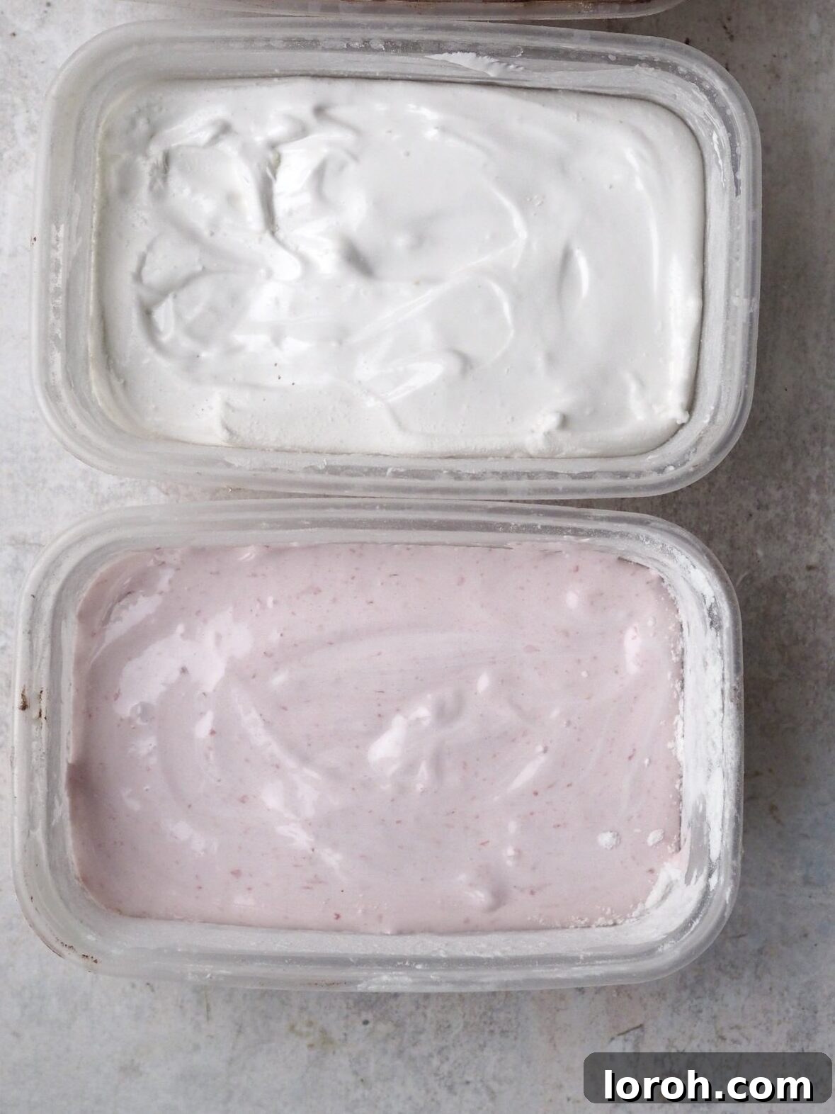 Marshmallow mixture being smoothed evenly into prepared containers, showcasing potential for different flavors.