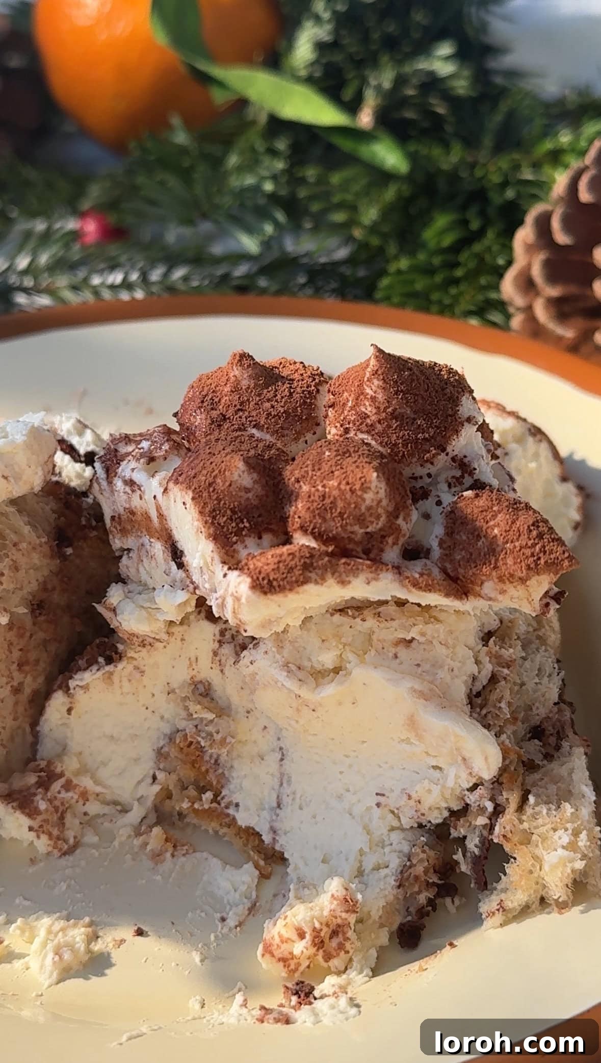 Close-up of a beautifully assembled Panettone Tiramisu with visible layers and a generous dusting of cocoa.