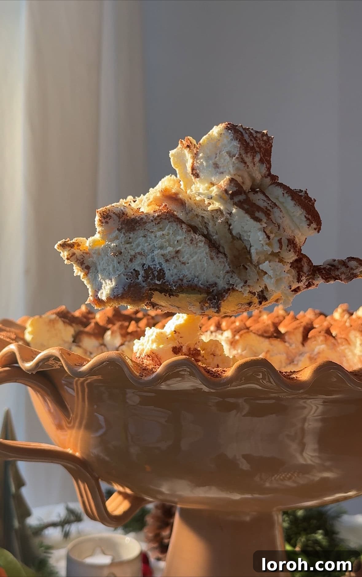 A large serving spoon scooping out a generous portion of Panettone Tiramisu, revealing the layers of cake and cream.