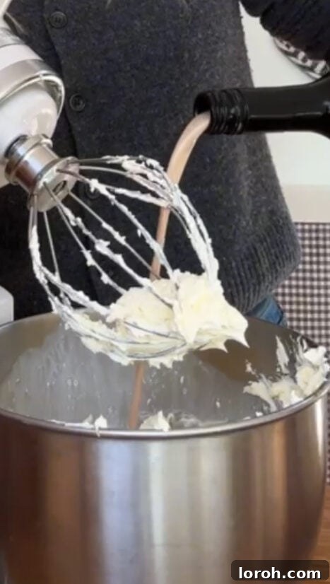 Pouring Baileys liqueur into the cream mixture for panettone tiramisu.