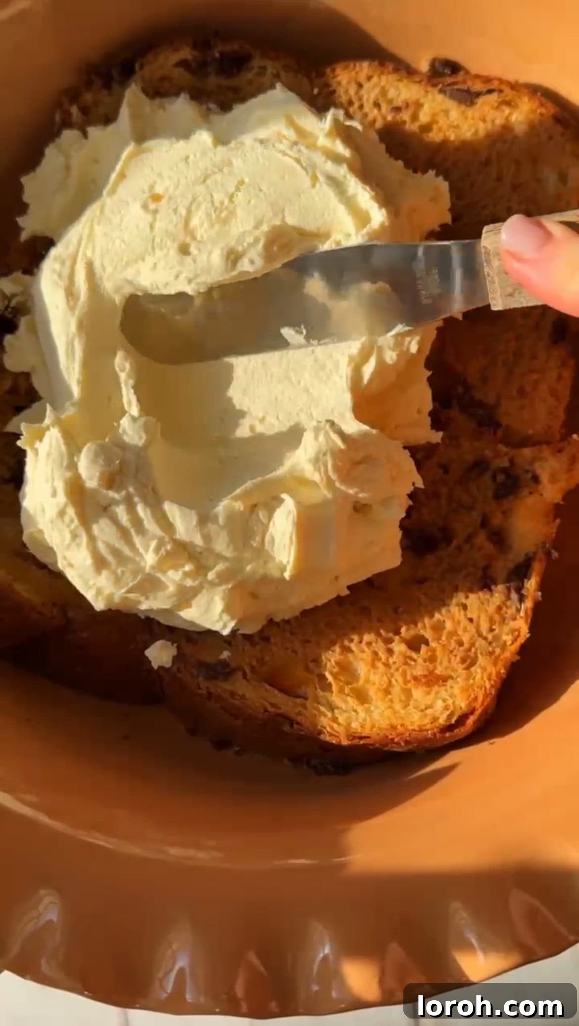 Spreading half of the mascarpone cream over the soaked panettone layer.