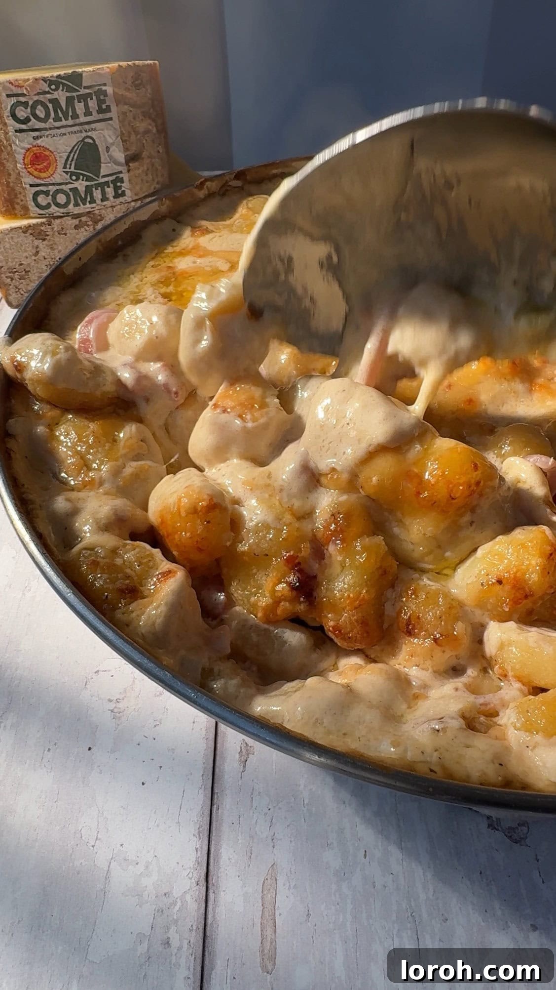 Scooping a generous portion of Gnocchiflette from the pan.