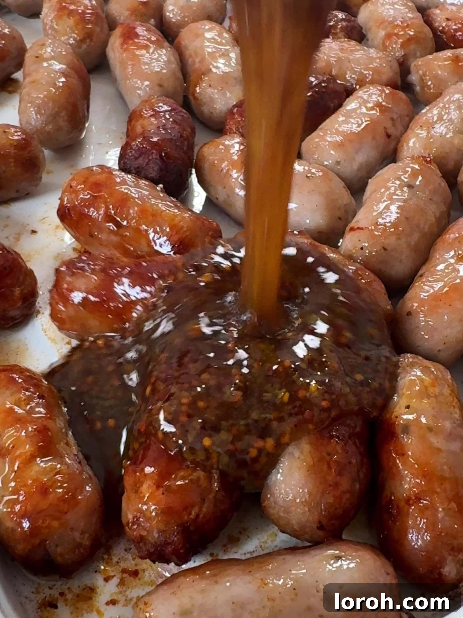 Pouring honey and mustard over the sausages.
