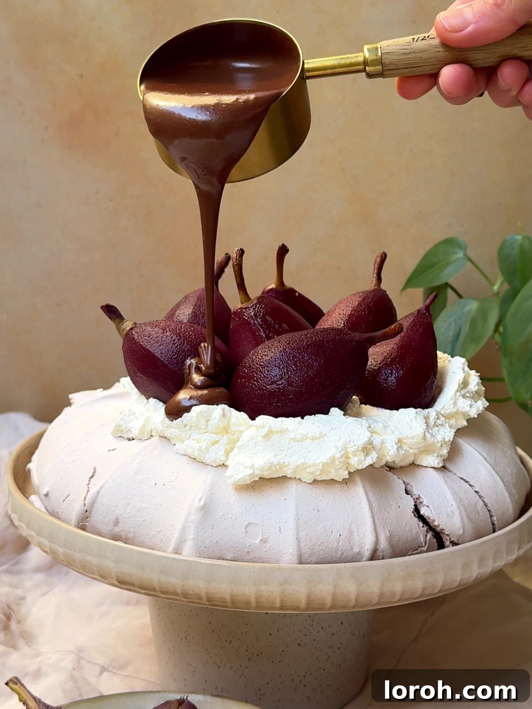 Holiday Spiced Pear Cloud 2 Pouring rich chocolate sauce over a festive Christmas Pavlova adorned with red wine poached pears.