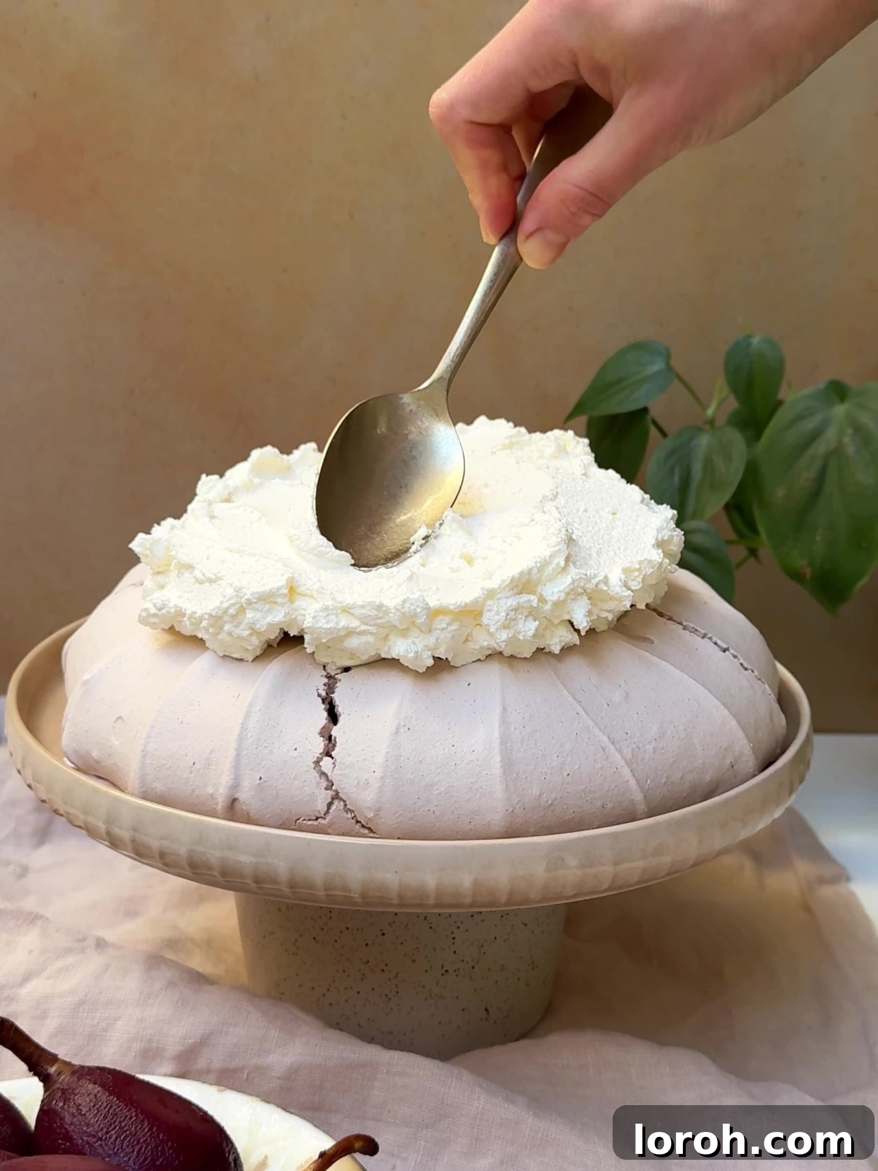 Holiday Spiced Pear Cloud 19 Spooning whipped cream on top of the pavlova.