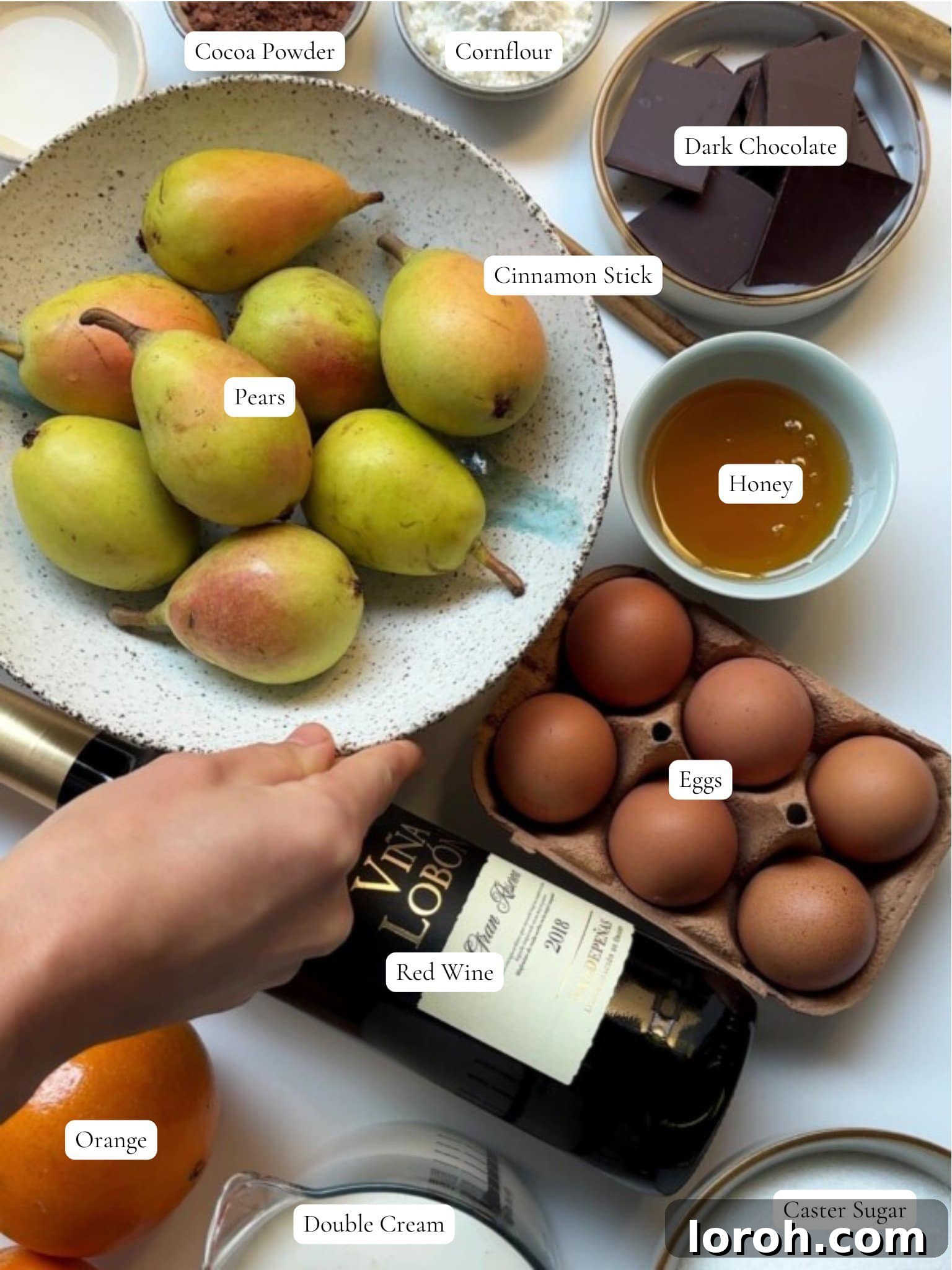 Holiday Spiced Pear Cloud 3 Assortment of ingredients for Christmas Pavlova, including pears, oranges, eggs, chocolate, and spices.