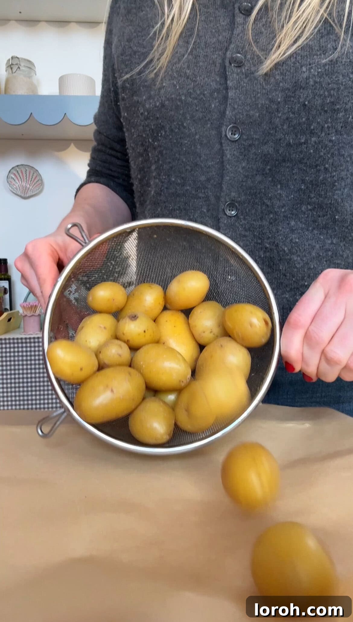 Boiled baby potatoes draining on a baking sheet, steaming gently.