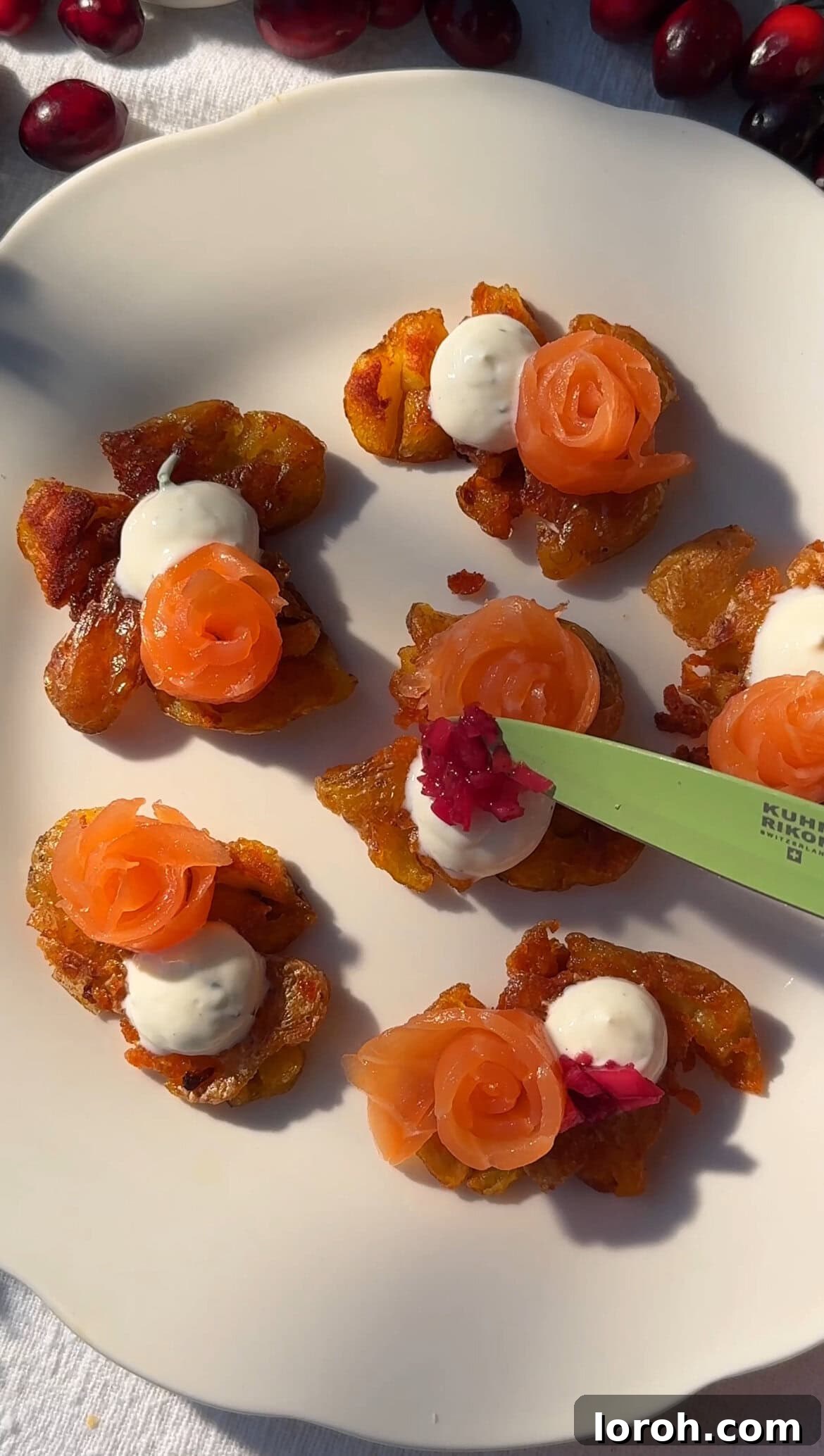 Smashed potatoes topped with crème fraîche, smoked salmon, and a spoonful of pickled red onions.