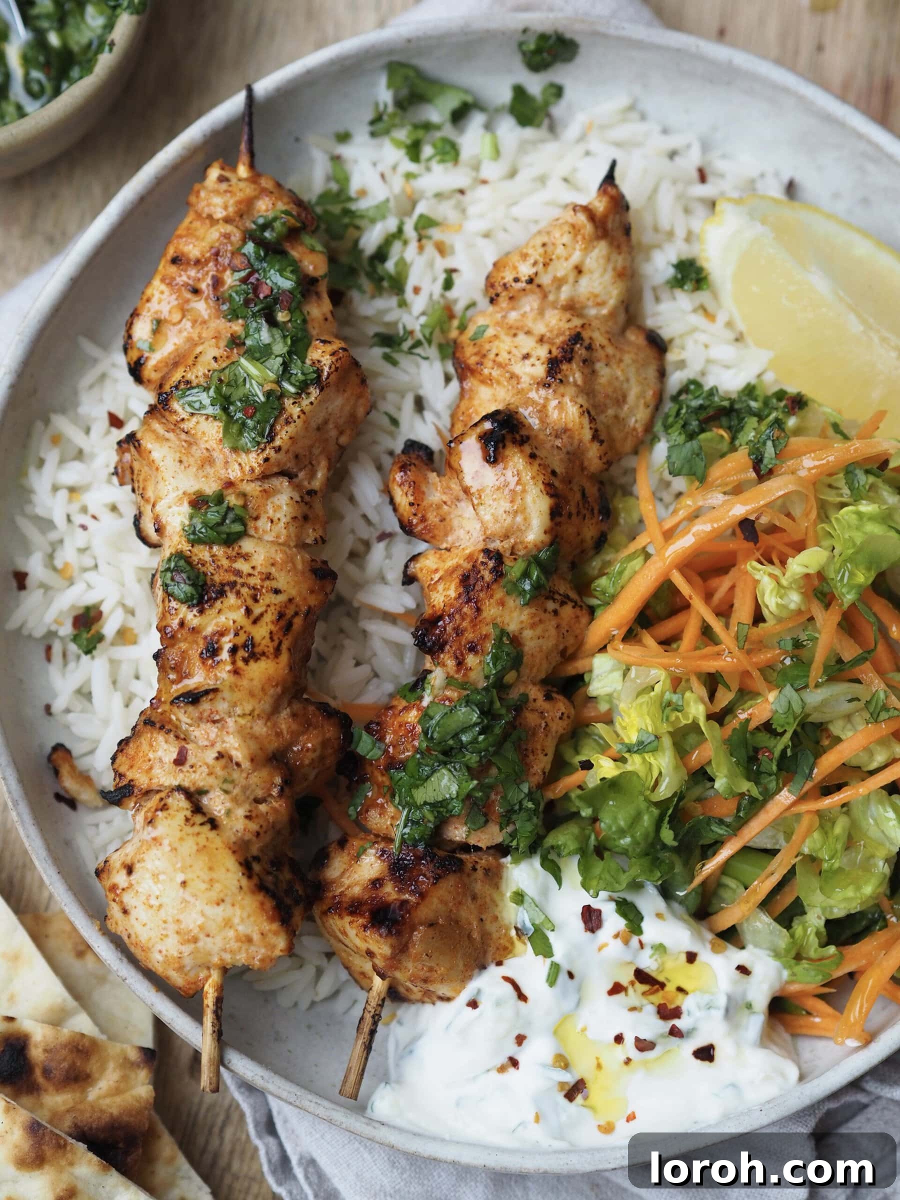 Delicious baked chicken skewers with crunchy salad and fluffy rice, ready to be enjoyed.