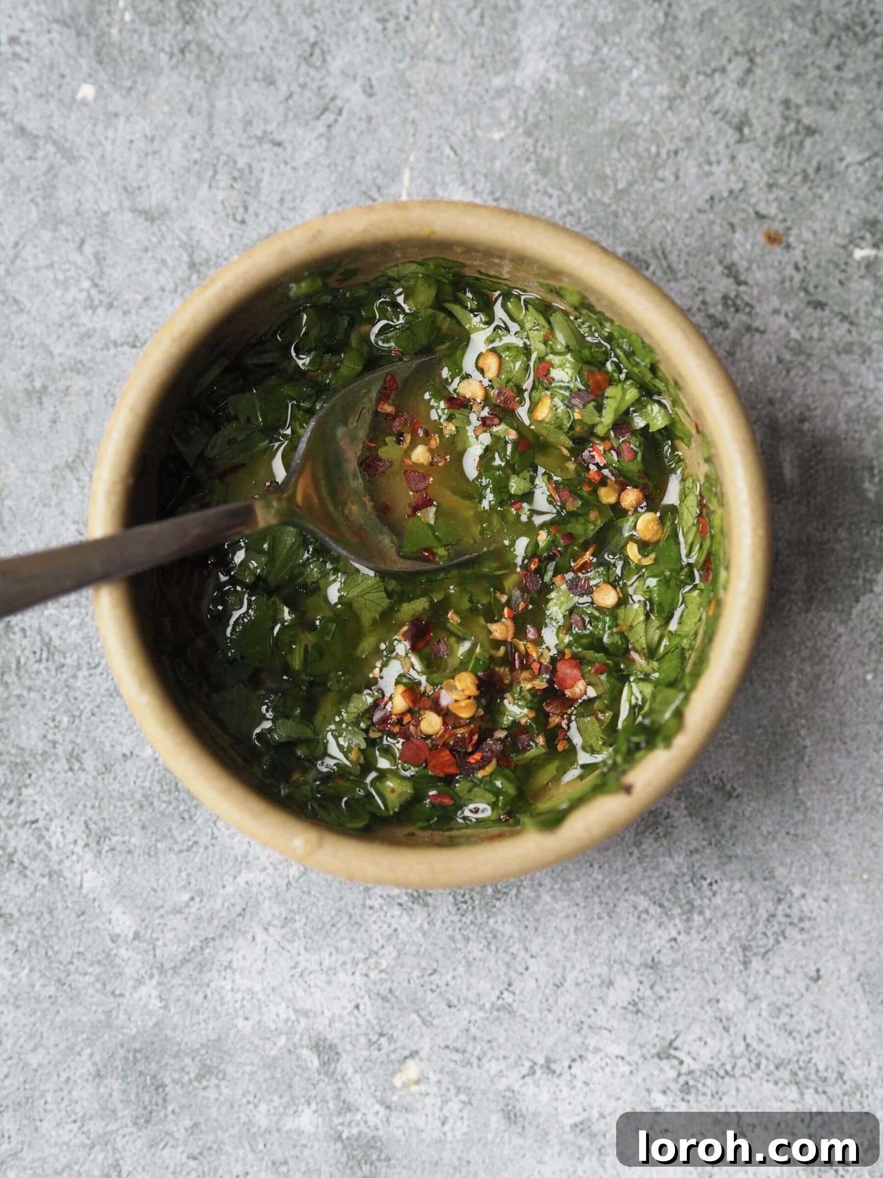 Fresh coriander, olive oil, and lemon juice being mixed for the herb drizzle.