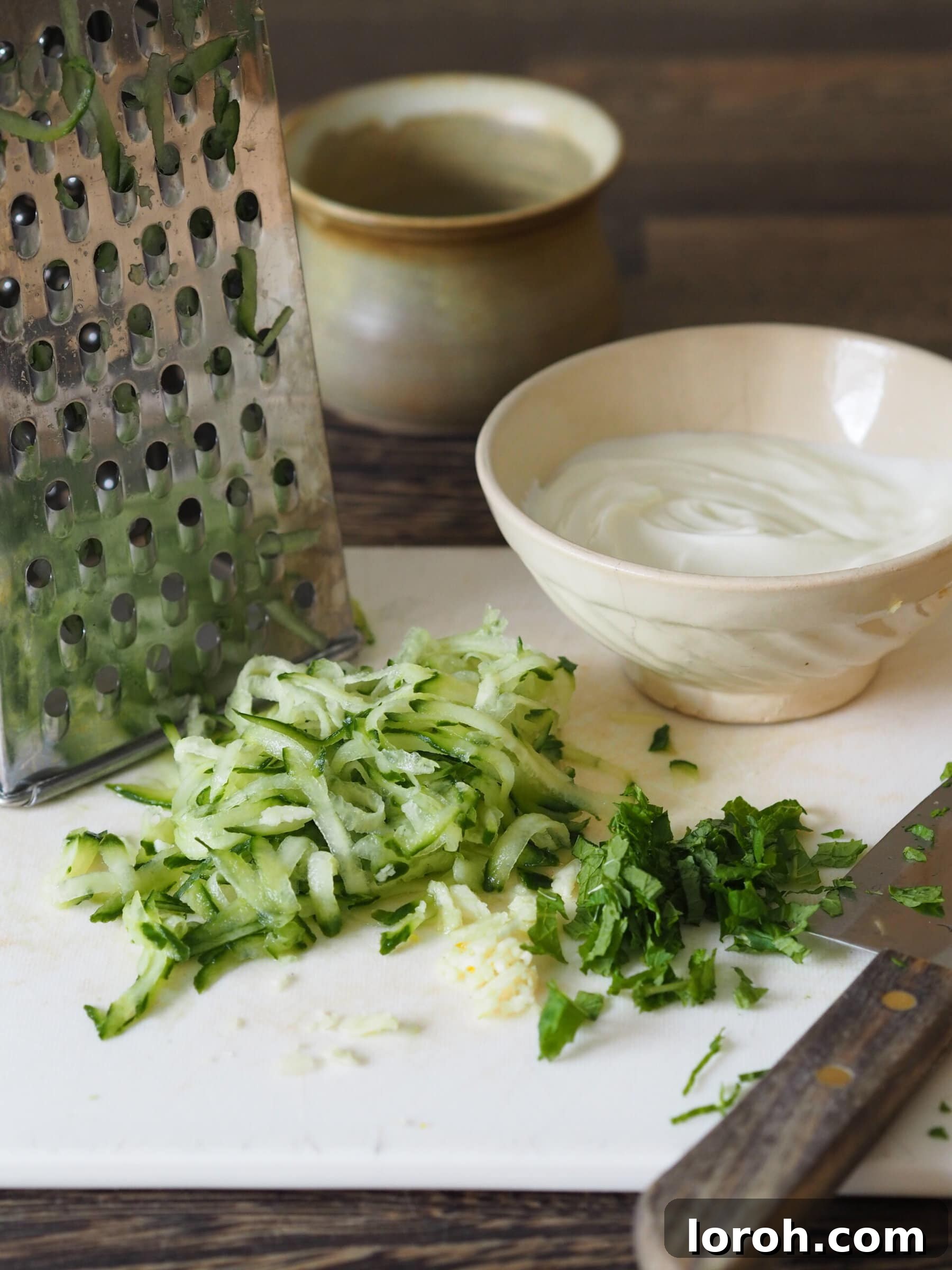 Grated cucumber and yogurt in a bowl, ingredients for raita.