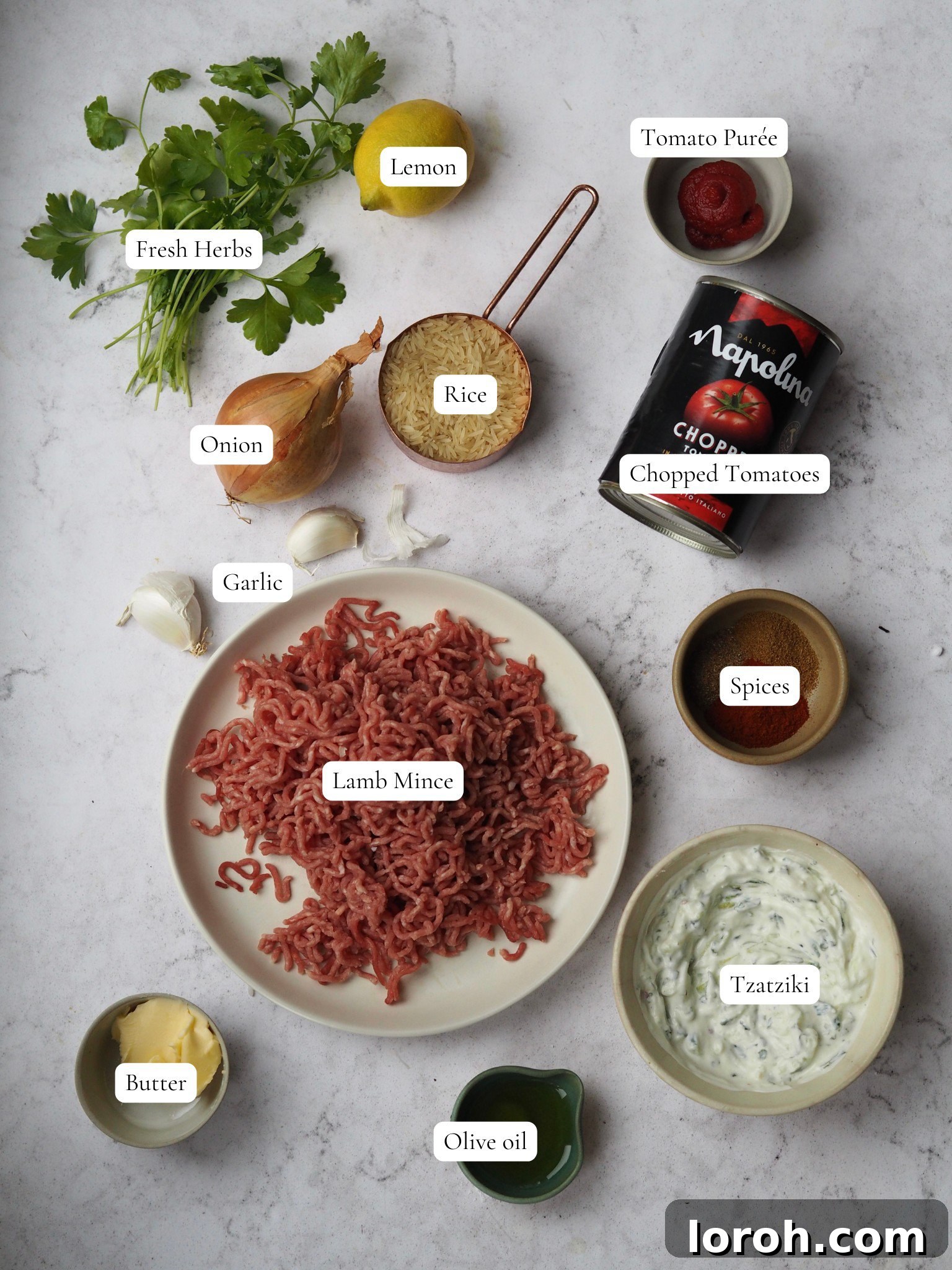 A bowl of fresh lamb mince, various spices, a head of garlic, and a tub of Greek yogurt, showcasing the key ingredients for the recipe.