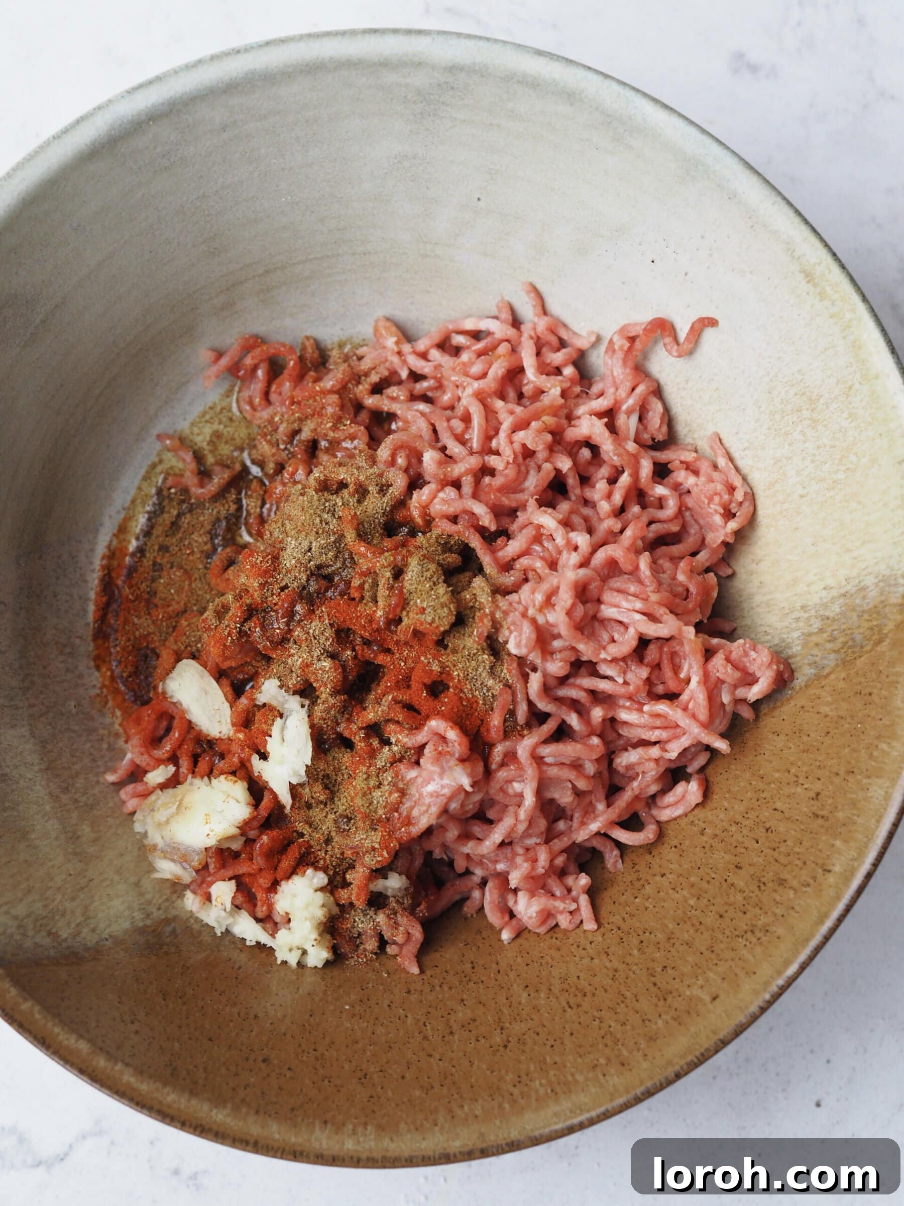 A bowl of lamb mince mixed with spices and garlic, ready for shaping.