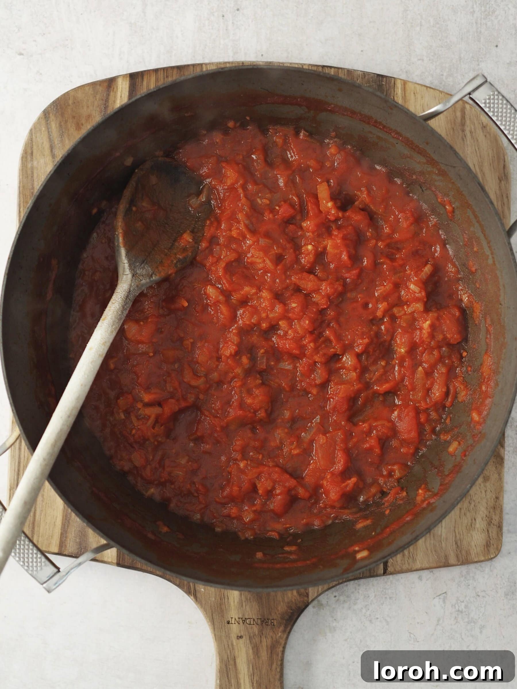 Onions and garlic sautéing in a pan, forming the base for the tomato sauce.