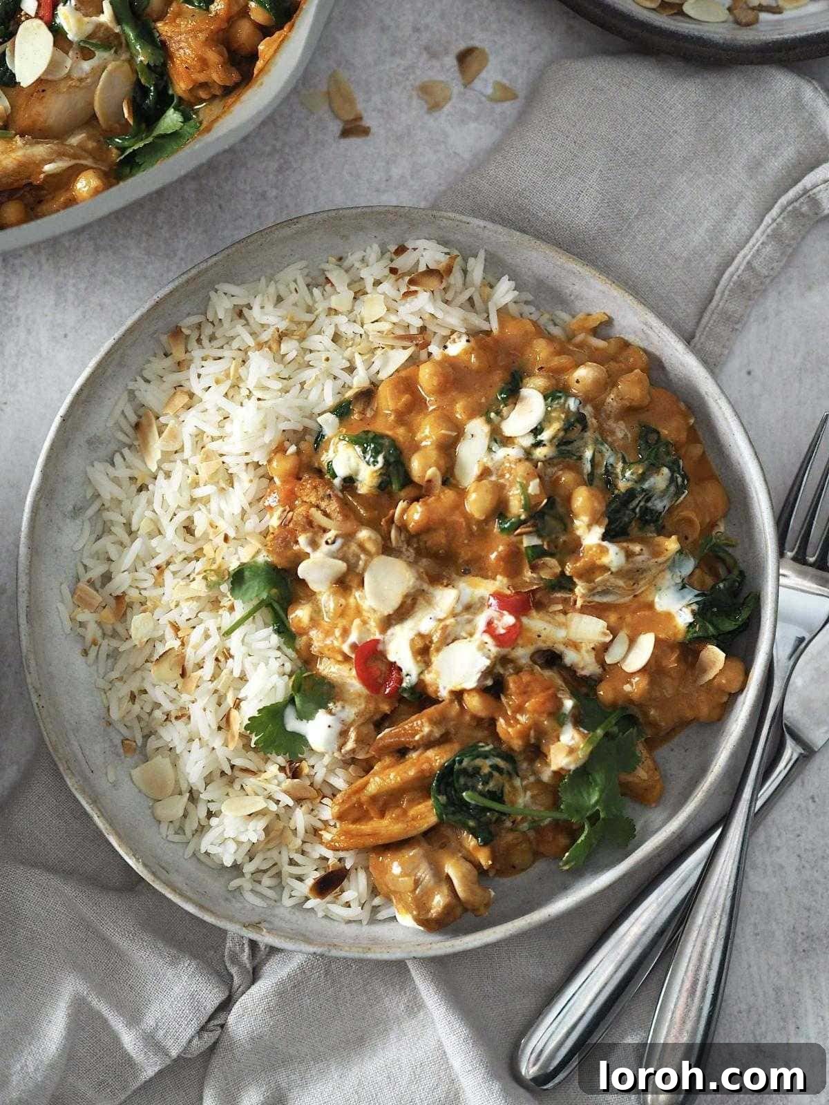 Golden Chicken & Chickpea Curry 2 chicken and chickpea curry garnished with yoghurt and herbs served with rice.
