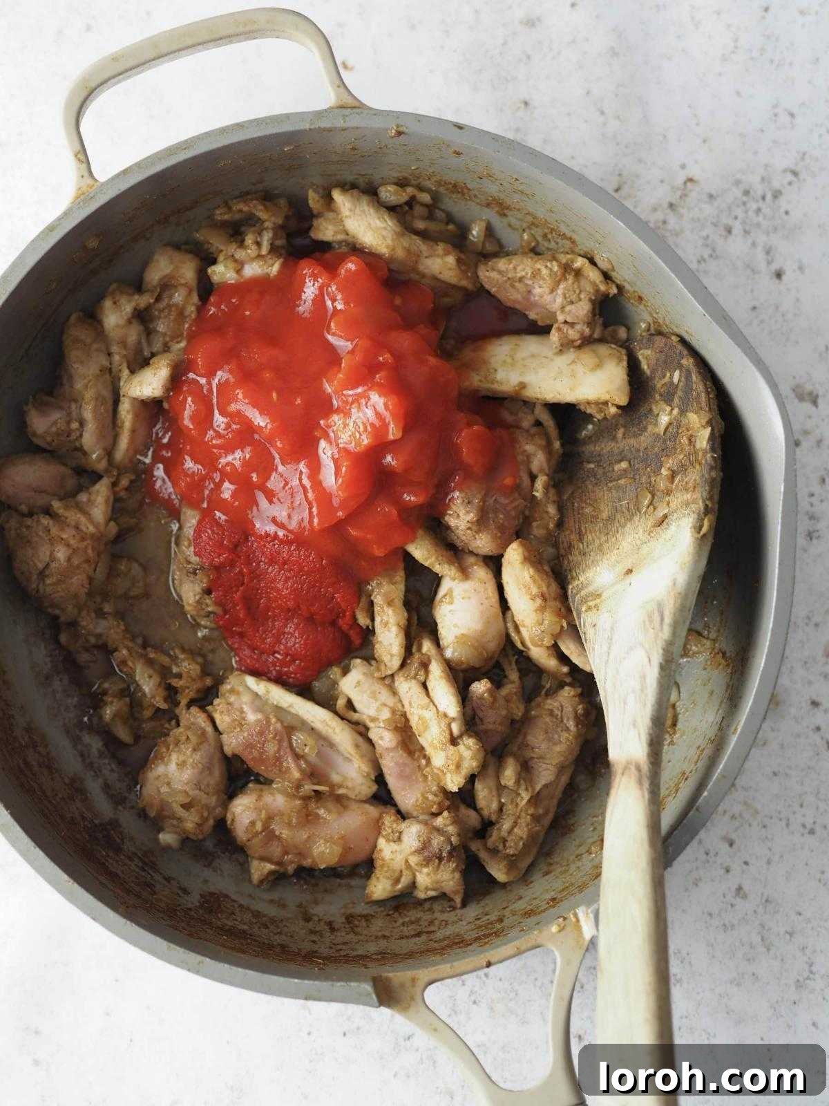 Golden Chicken & Chickpea Curry 8 adding chopped tomatoes to the chicken.
