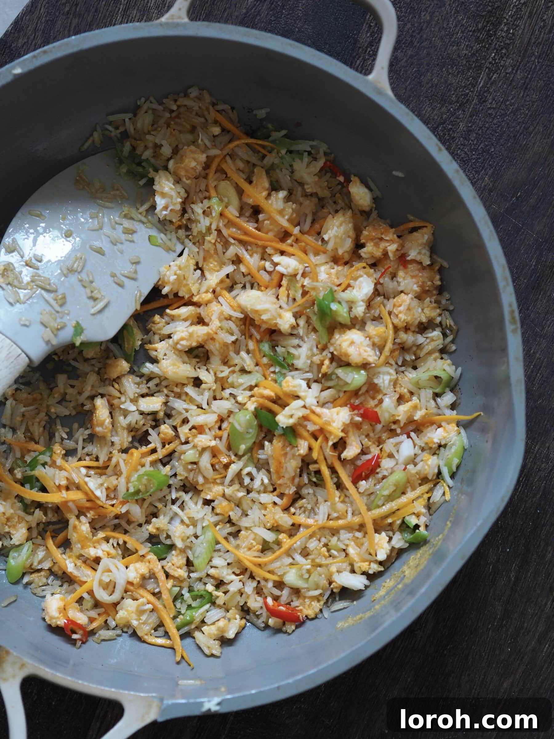 Mixing egg into fried rice as a side to air fryer pork belly.