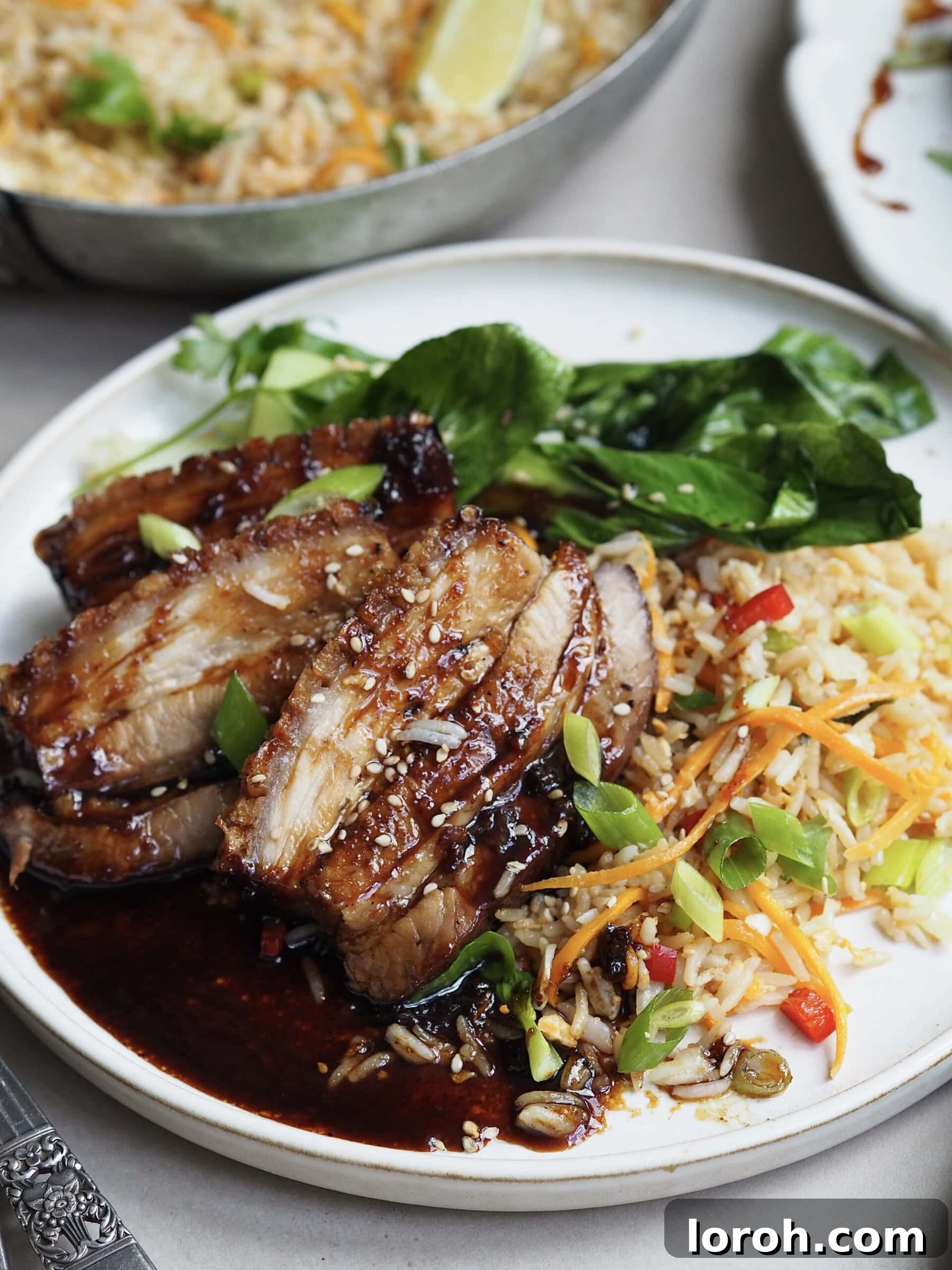 Plated air fryer pork belly with egg fried rice and pak choi.