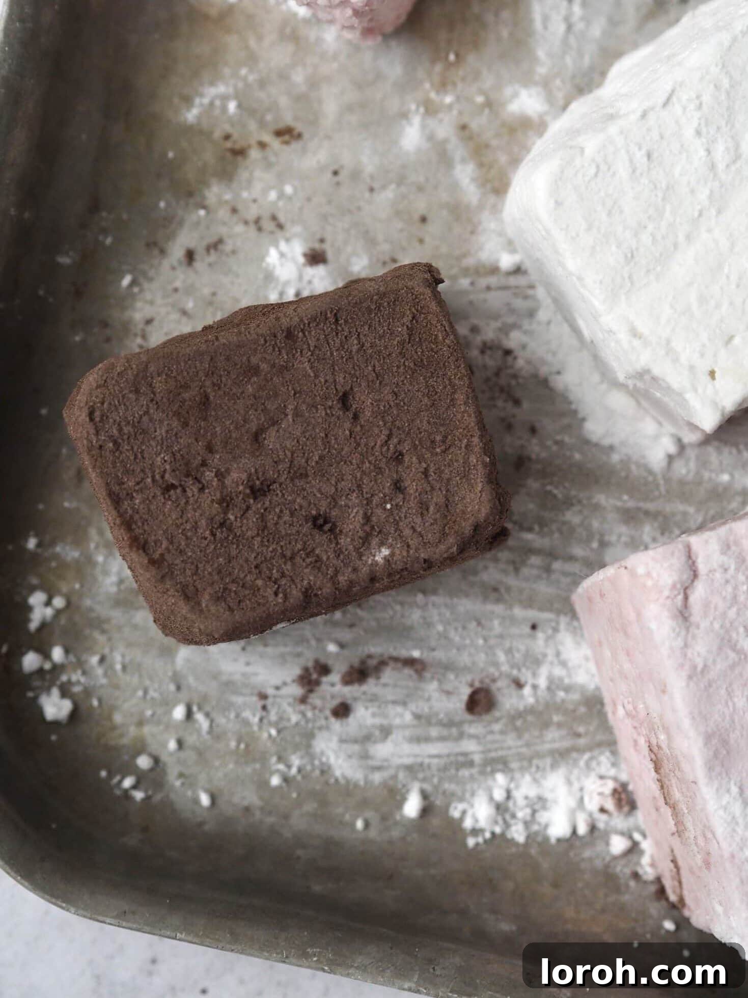 Individual chocolate marshmallows on a baking tray, ready for storage or serving.