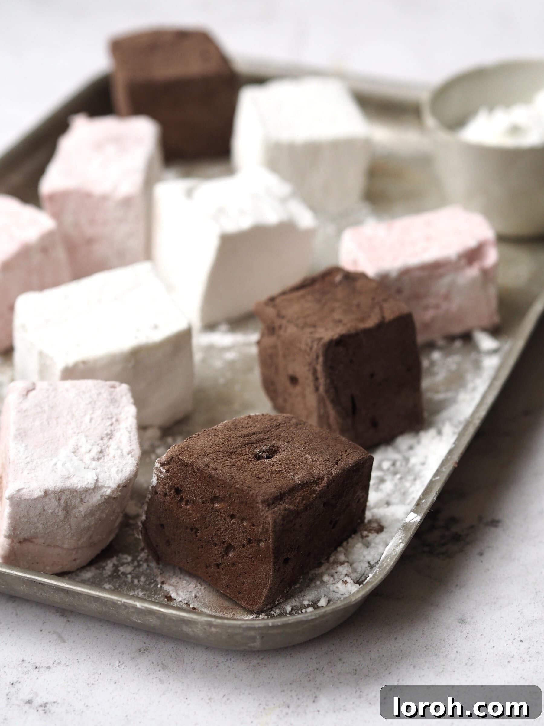Beautifully cut homemade marshmallows dusted with cocoa.