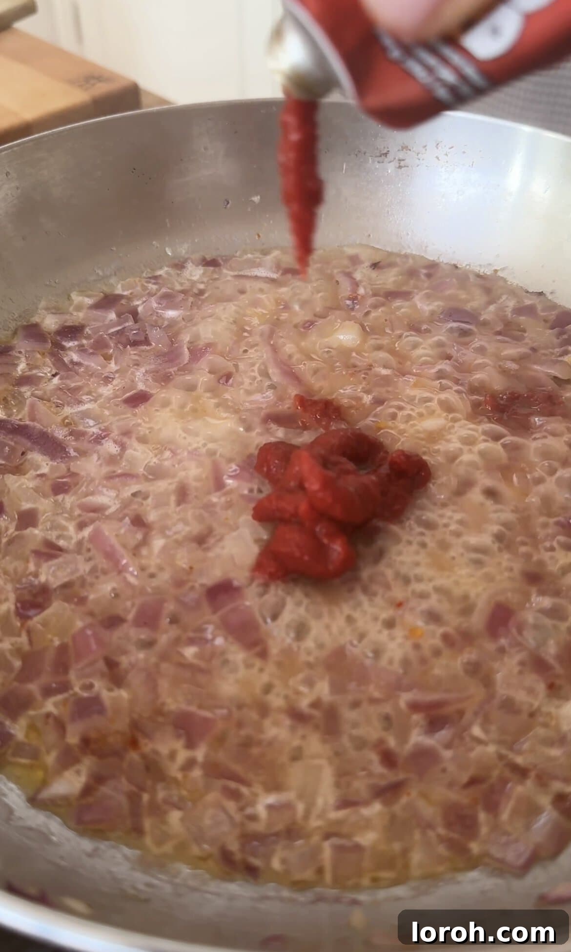 Velvet Vodka Chicken Pasta 6 Adding rich tomato purée to the onion and garlic base for the pasta sauce.
