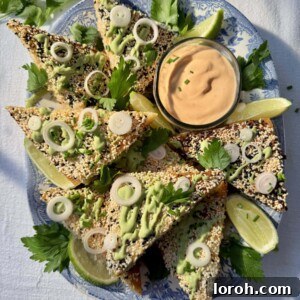 Sesame prawn toasts with fresh lime and green sauce drizzle, artfully arranged for a delightful presentation.
