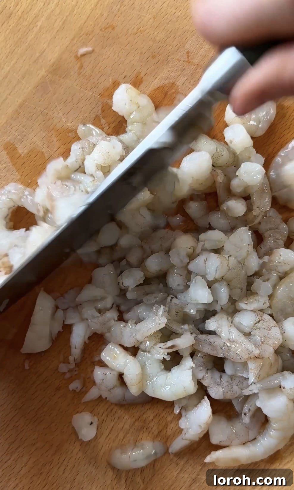 Golden Sesame Shrimp Crisps 4 Finely chopping raw prawns on a cutting board, preparing them for the toast mixture.