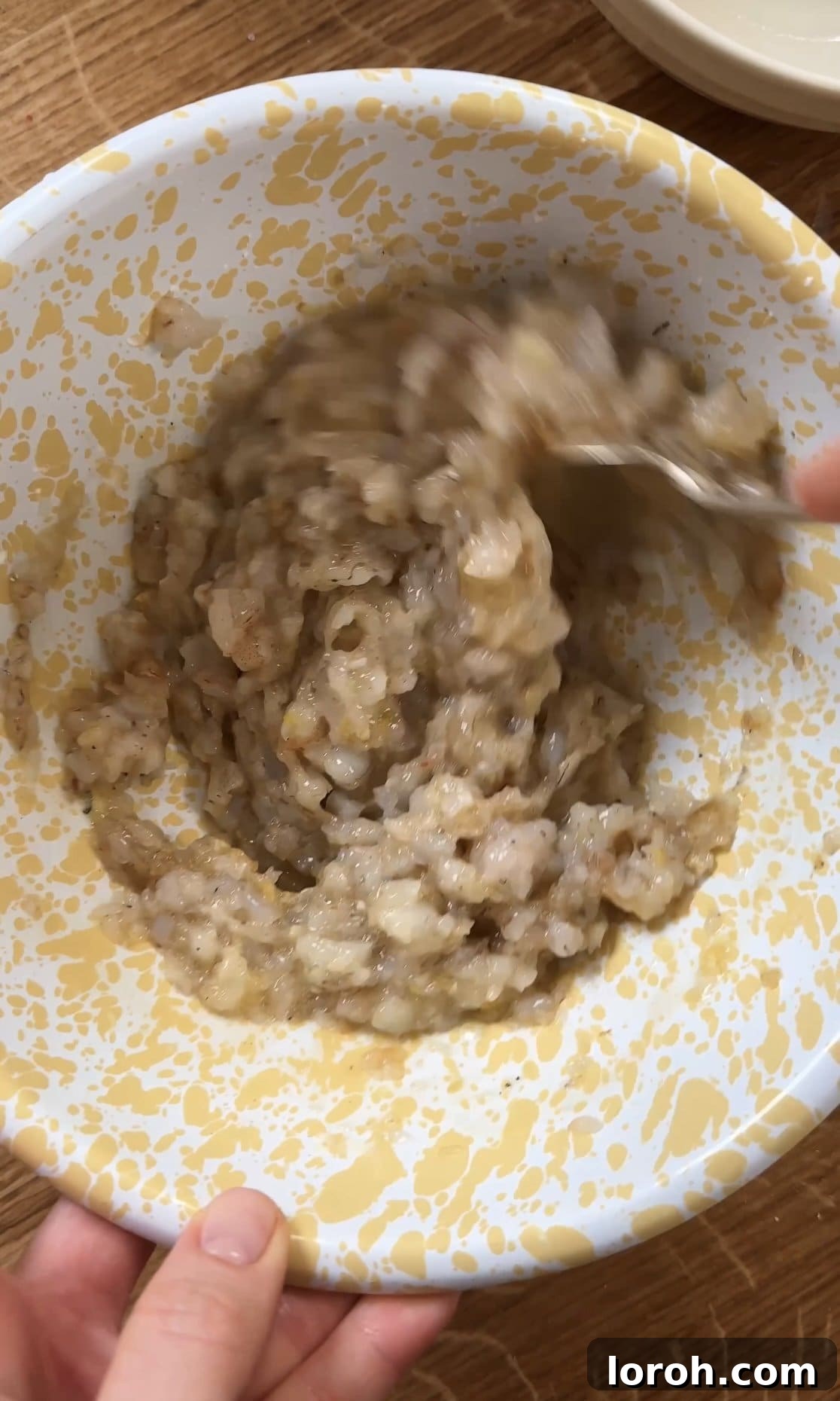 Golden Sesame Shrimp Crisps 6 Mixing the prawn mixture thoroughly in a bowl with a spoon.