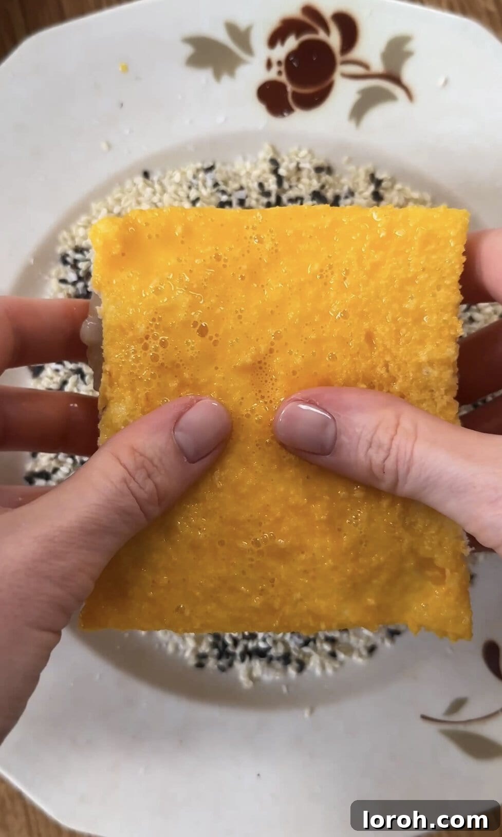 Golden Sesame Shrimp Crisps 9 Dipping the prawn toast sandwich into a bowl of sesame seeds for a thorough coating.