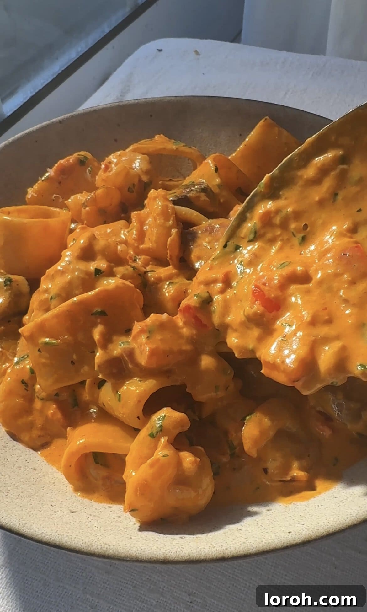 Smoky Chorizo Prawn Pasta 11 A serving of prawn and chorizo pasta being spooned into a bowl, ready to enjoy.