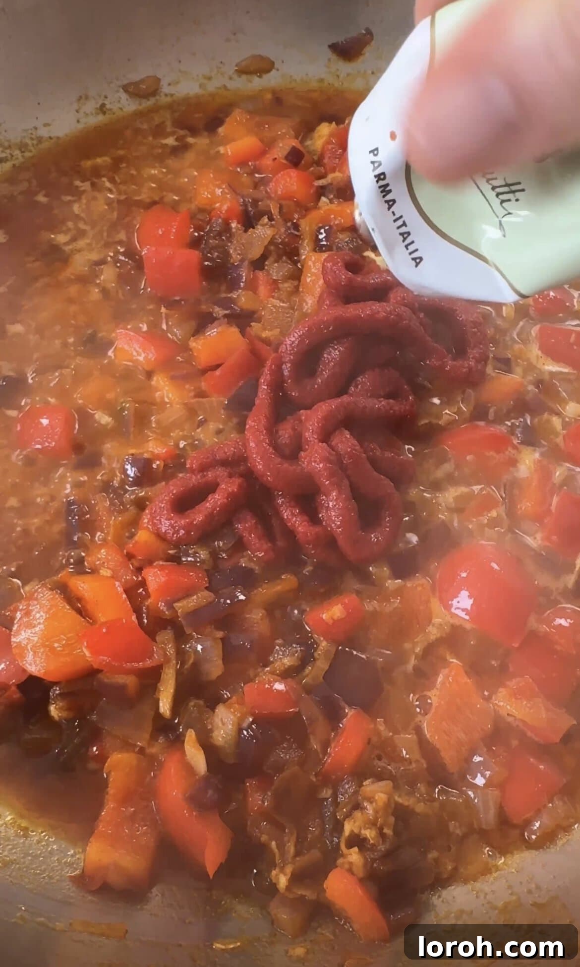 Smoky Chorizo Prawn Pasta 7 Adding rich tomato purée to the sautéed vegetables in the pan.