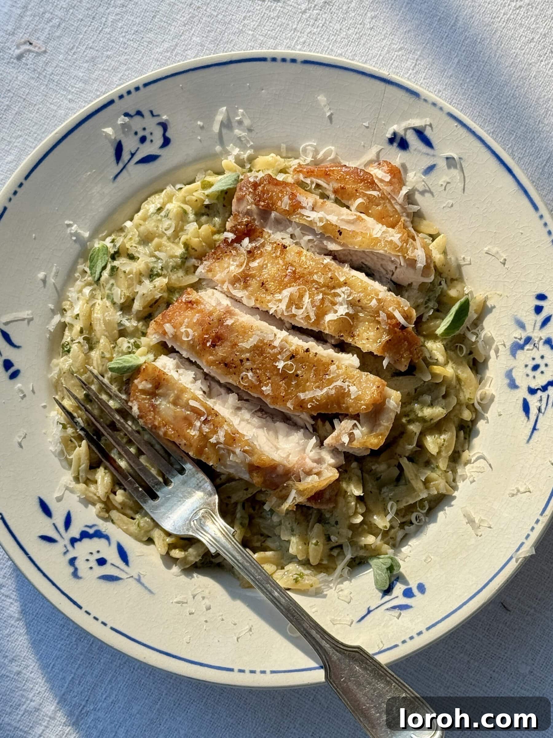 Zesty Lemon Chicken Orzo 12 lemon chicken orzo in a bowl with blue flowers, a close-up of the finished dish.