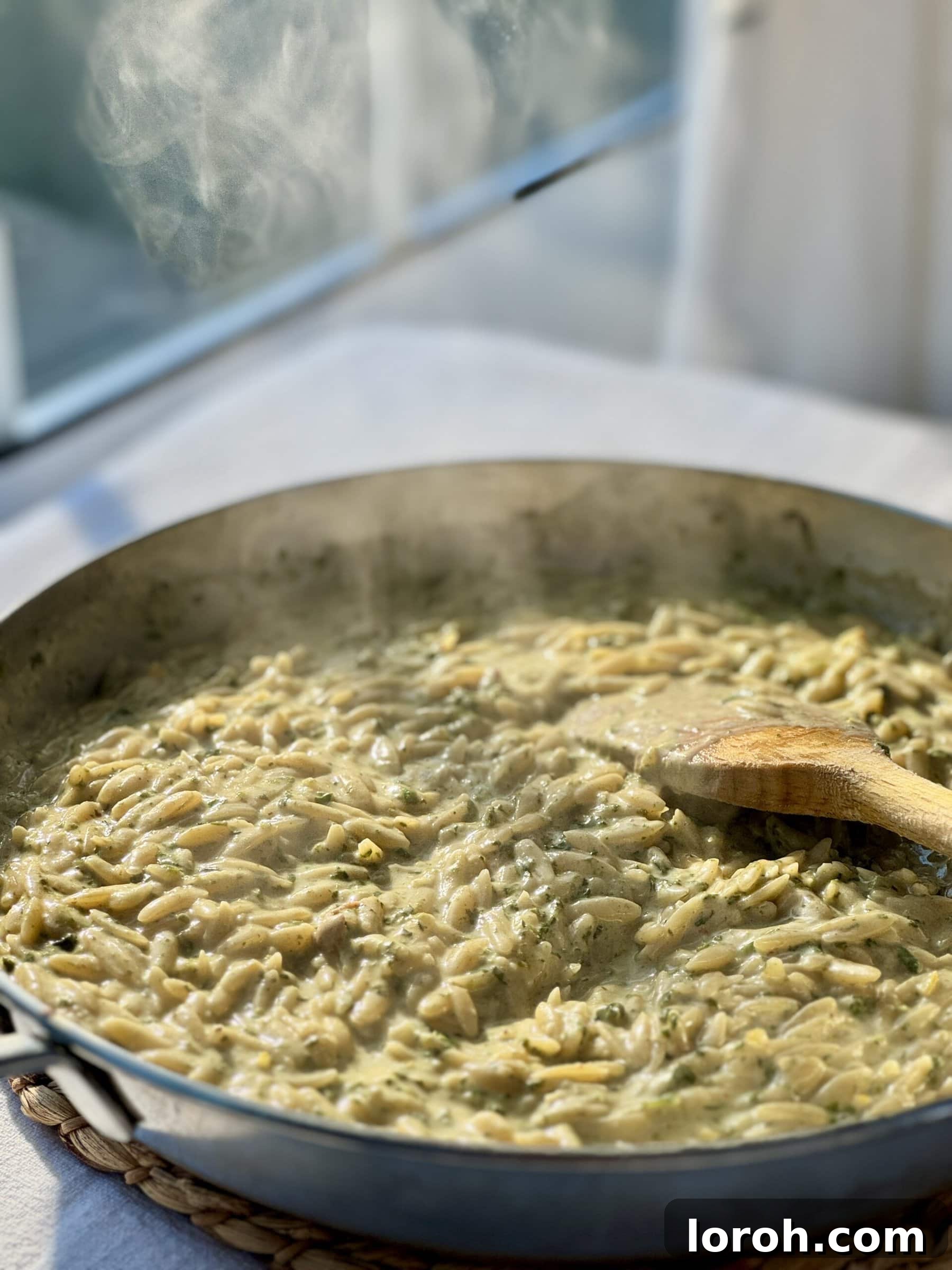 Zesty Lemon Chicken Orzo 3 steaming pan of lemon orzo, highlighting the creamy texture and inviting aroma.