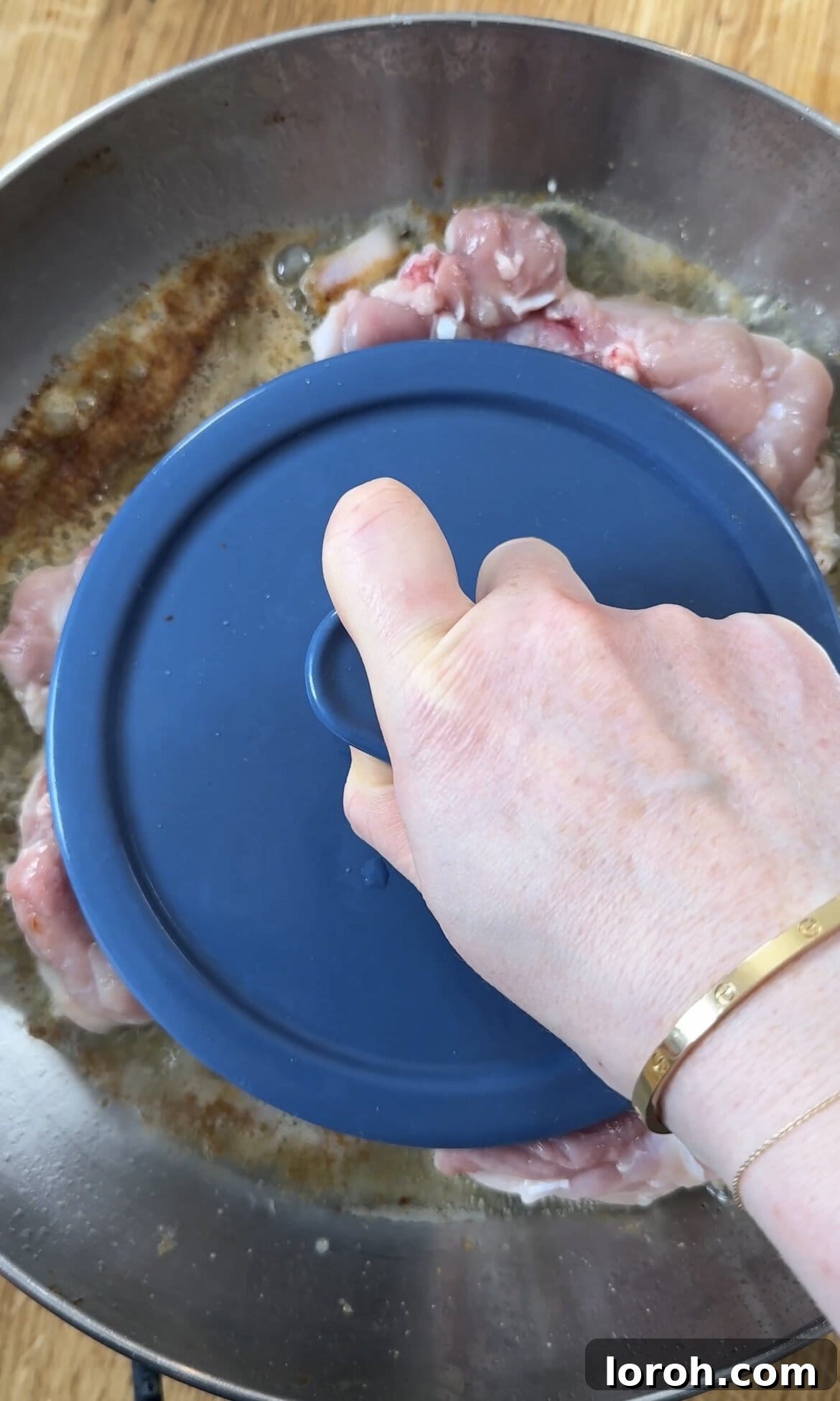 Zesty Lemon Chicken Orzo 5 frying chicken thighs with a weight on top for extra crispiness.