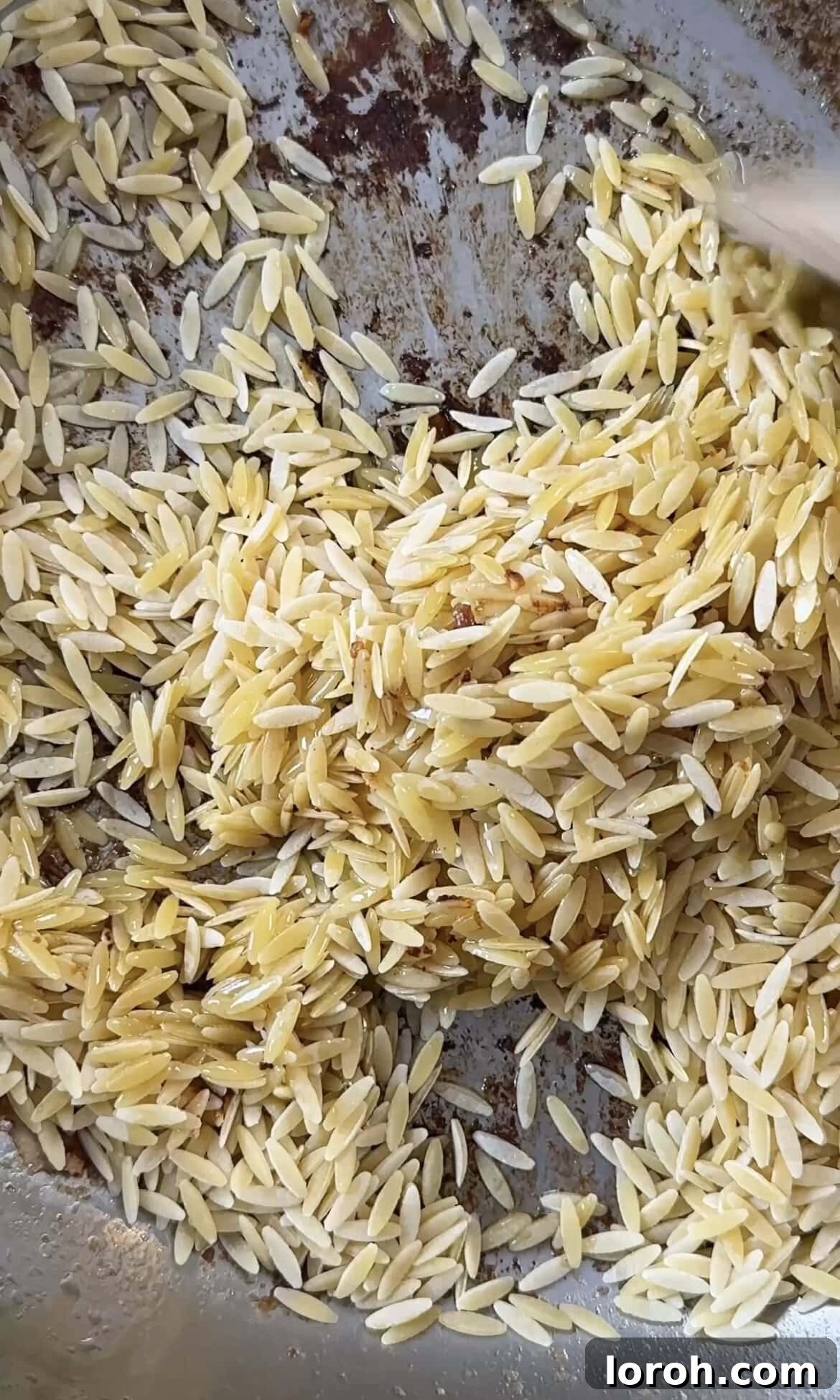 Zesty Lemon Chicken Orzo 7 toasting orzo in the pan with lemon-infused butter and chicken drippings.